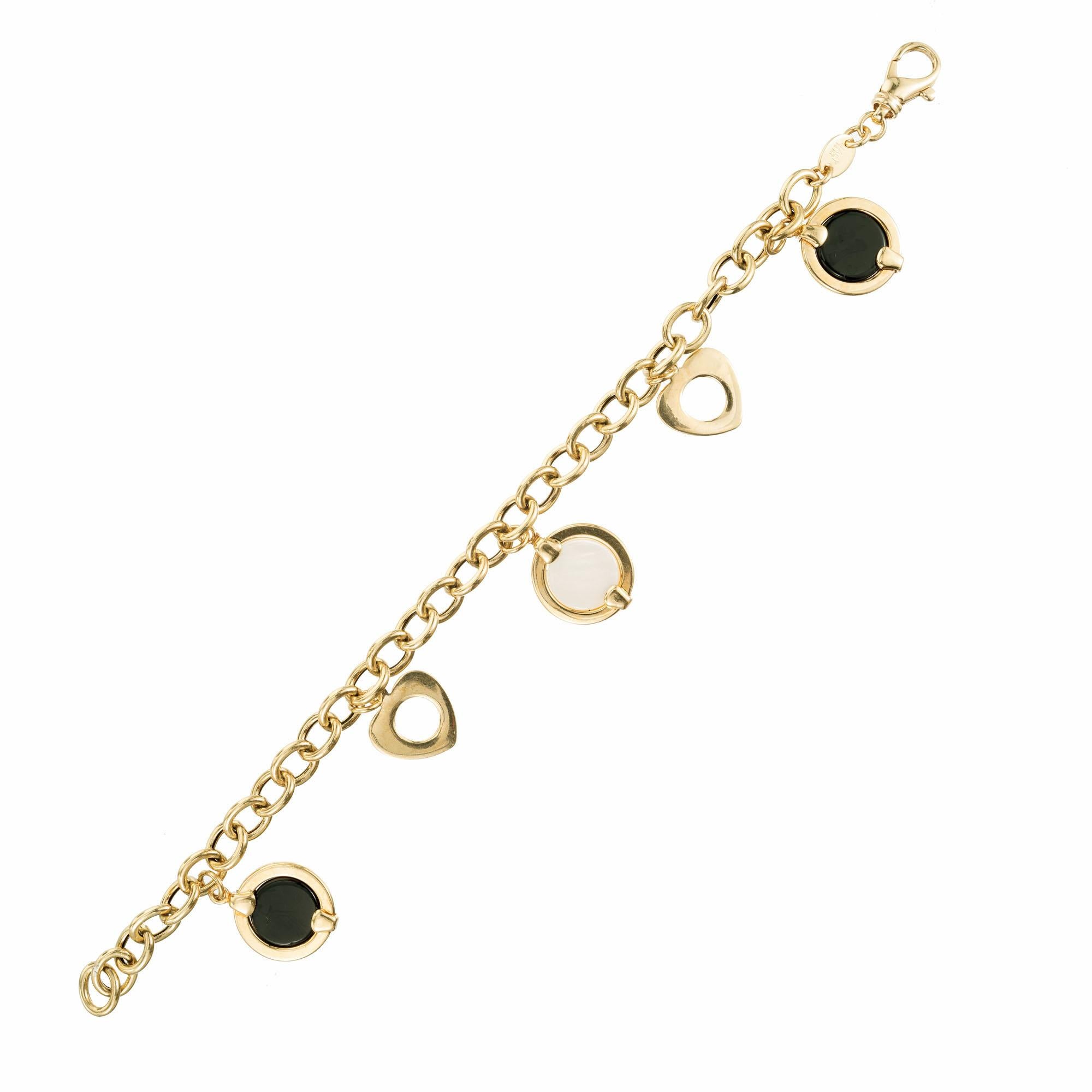 14k yellow gold oval shaped open link charm bracelet containing alternating charms of black onyx discs wrapped in yellow gold, open hearts and a mother of pearl disc wrapped in yellow gold in the center. 7 inches.

2 round black onyx discs, 10mm