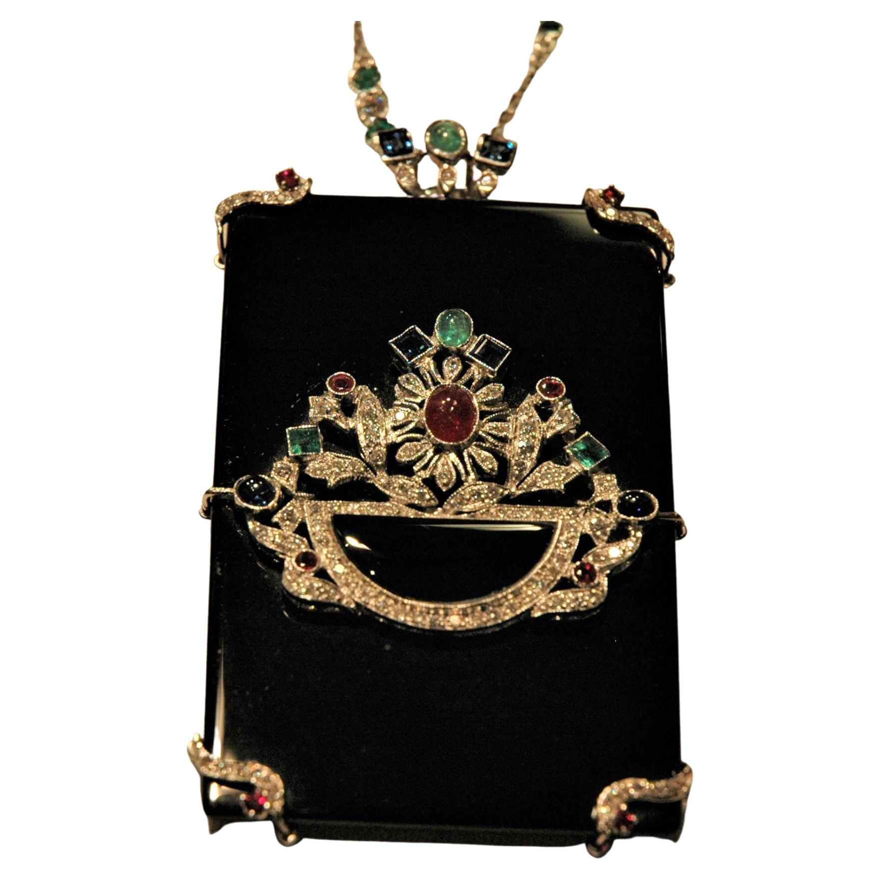 This is a very special pendant, handmade in Italy, using as a base a rectangular slab of onyx, on which you can see a flower basket with diamonds (0.80 carats) and precious stones. There are two cabochon emeralds, two carré emeralds, two carré