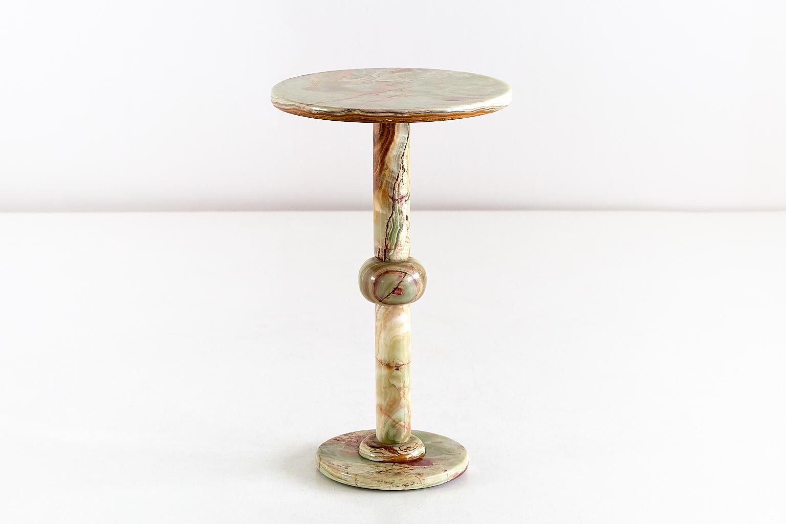 This elegant side table was produced in Italy in the 1960s. The pedestal base and top are all made of multicolored onyx. The different hues and intensitities of red, white and green give the table a refined and striking appearance.