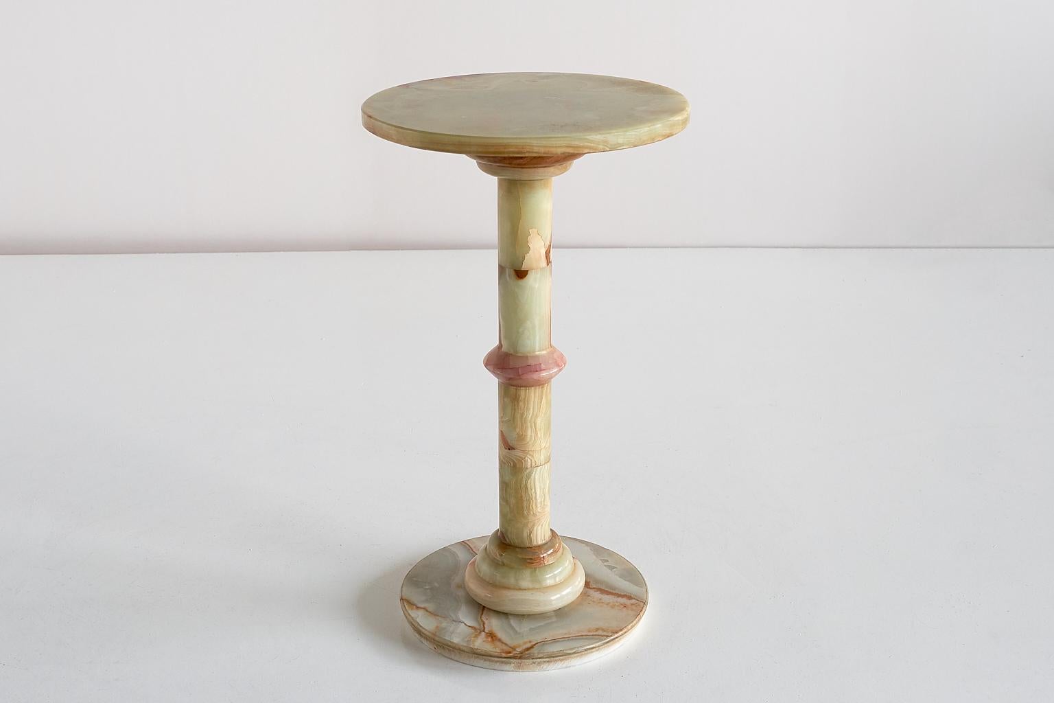 This elegant side table was produced in Italy in the 1960s. The pedestal base and top are all made of multicolored onyx. The different hues and intensitities of red, white and pastel green give the table a refined and striking appearance.