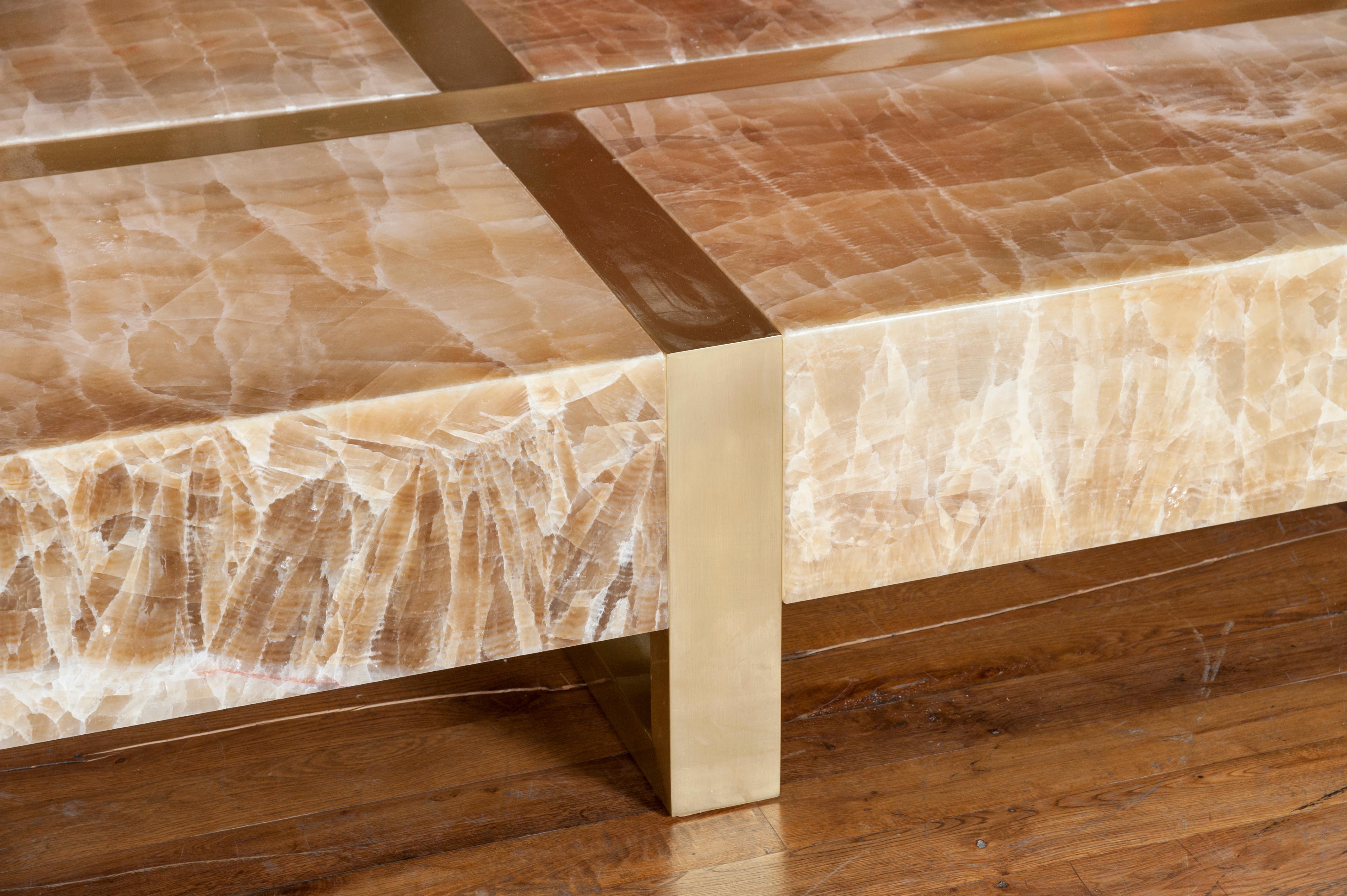 A large polished onyx coffee table with structure in brass. Customizable dimensions. Creation by Studio Glustin.