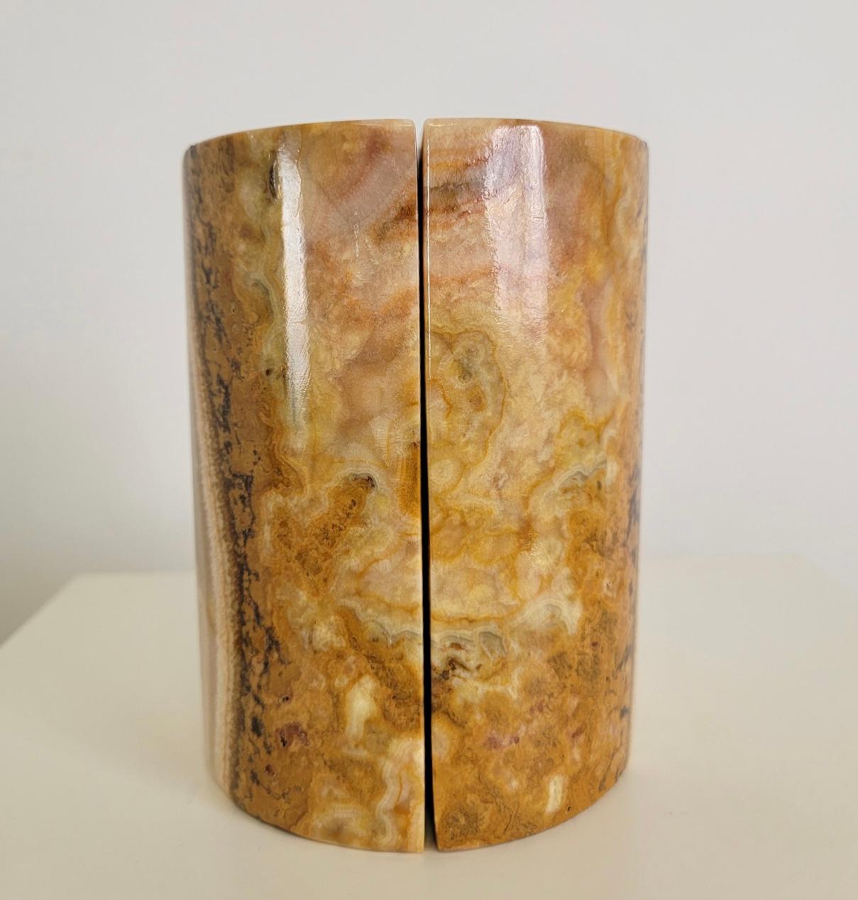 Gorgeous pair of onyx stone bookends.
The onyx which is a stone that has beautiful veining and a variety of colours throughout. These bookends come as a pair and form a round cylinder shape and each piece is a half circle. They can be used as