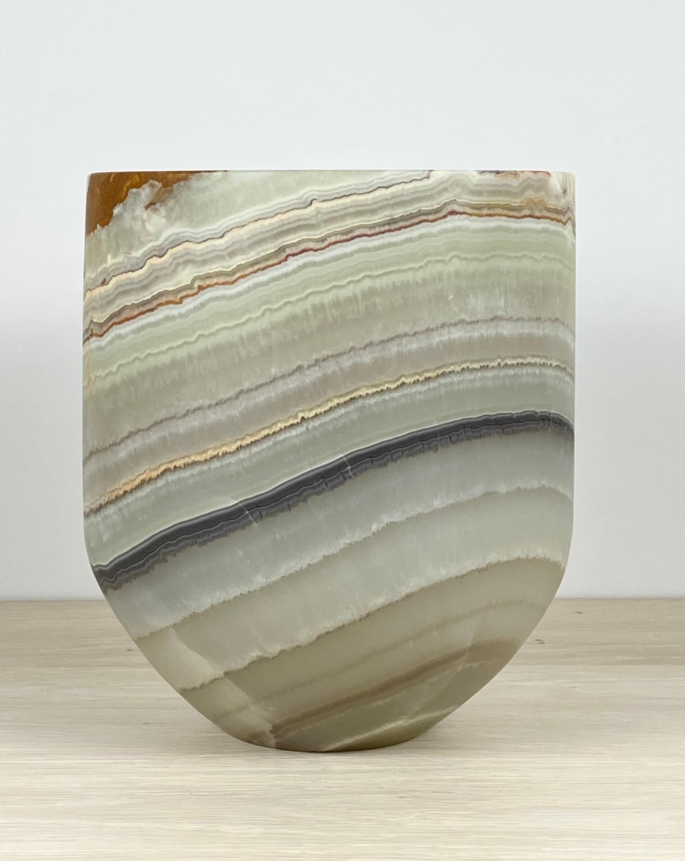 A stunning onyx planter with a polished edge. This one of a kind planter is carved from a single piece of onyx. This beautiful piece has naturally occurring mineral formations in tones of sage, terracotta, beige and black. An excellent decorative