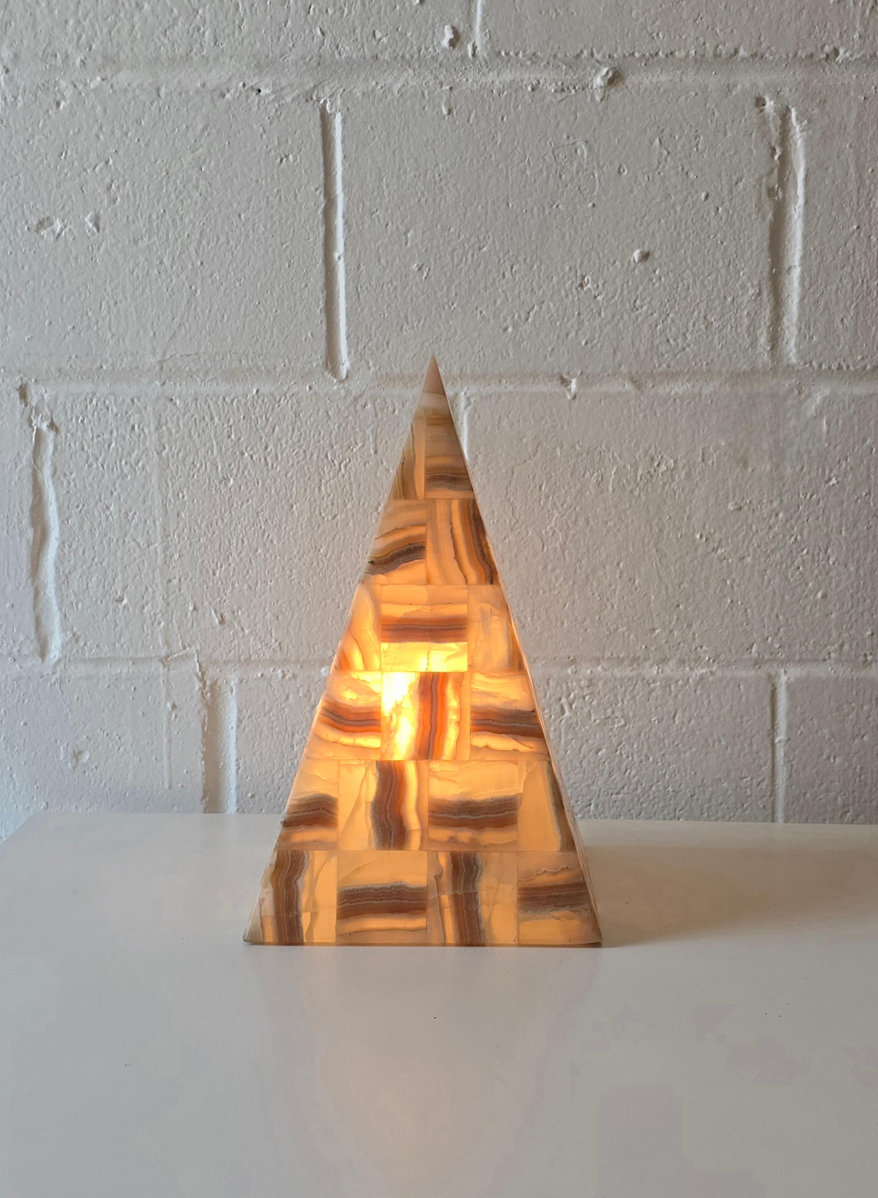 Estupenda lámpara piramidal de piedra de ónice. La lámpara está formada por piezas de piedra configuradas entre sí, lo que le da un acabado desconcertante. Se ilumina de maravilla y tiene el tamaño perfecto. Tiene un pequeño orificio en la parte