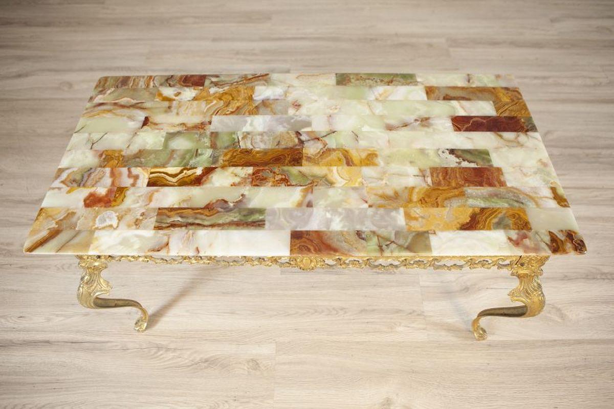 Onyx-Top Coffee Table From the 1960s

A coffee table with an onyx top, dated to the 1960s, featuring a richly decorated openwork apron and curved legs.