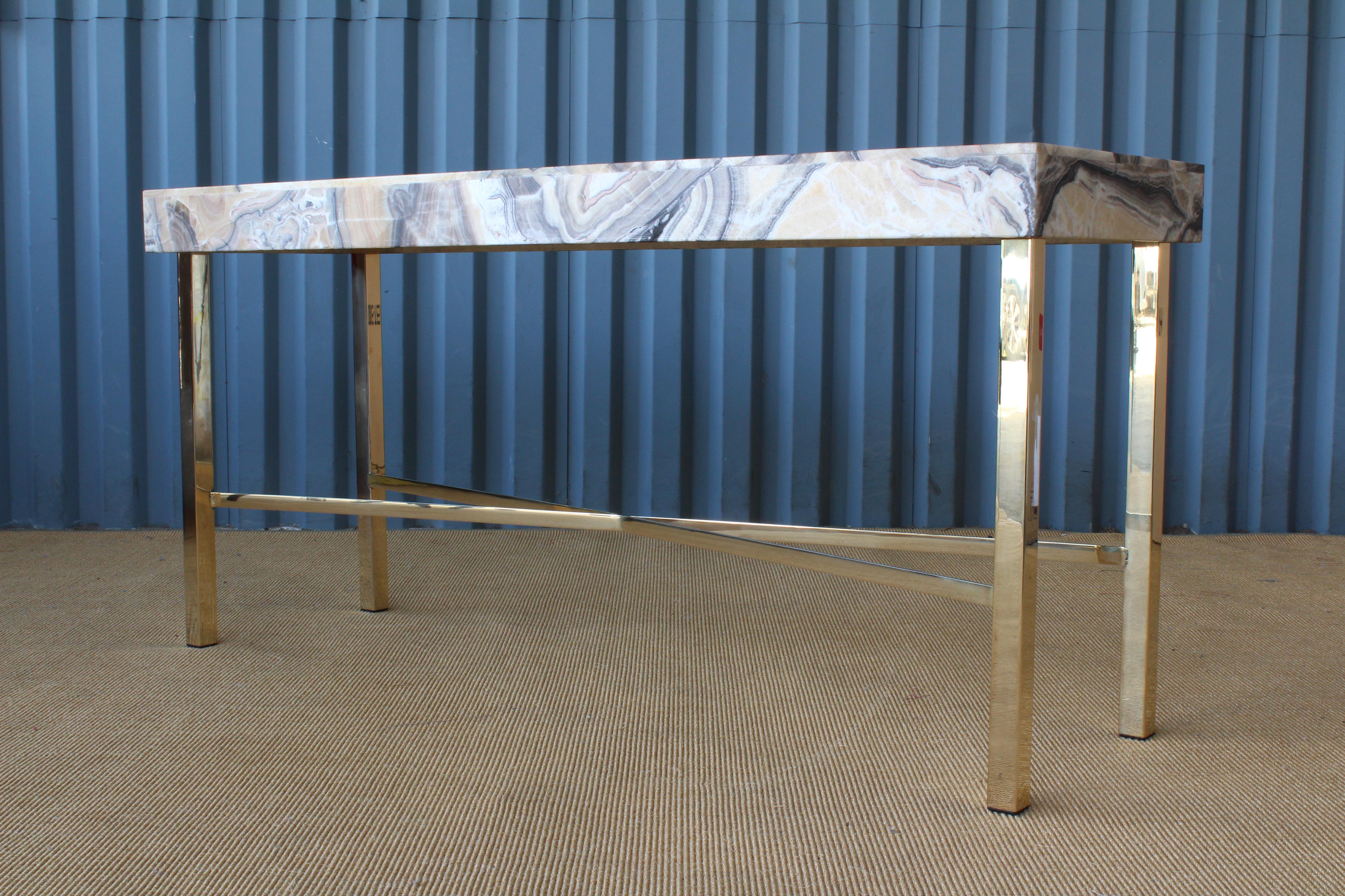 Onyx top console table on a custom brass-plated base.