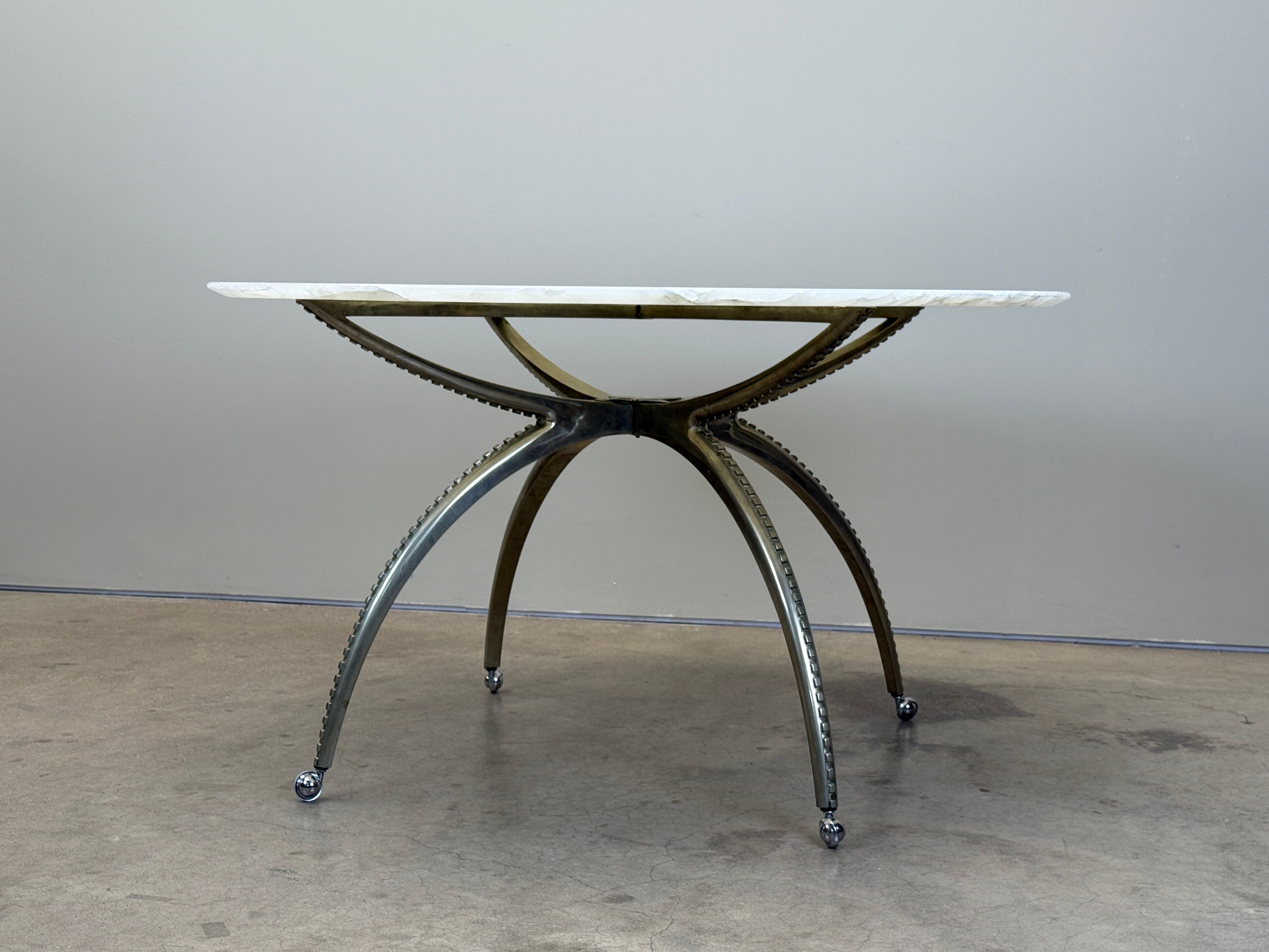 A nickel plated game table on casters with onyx top. 