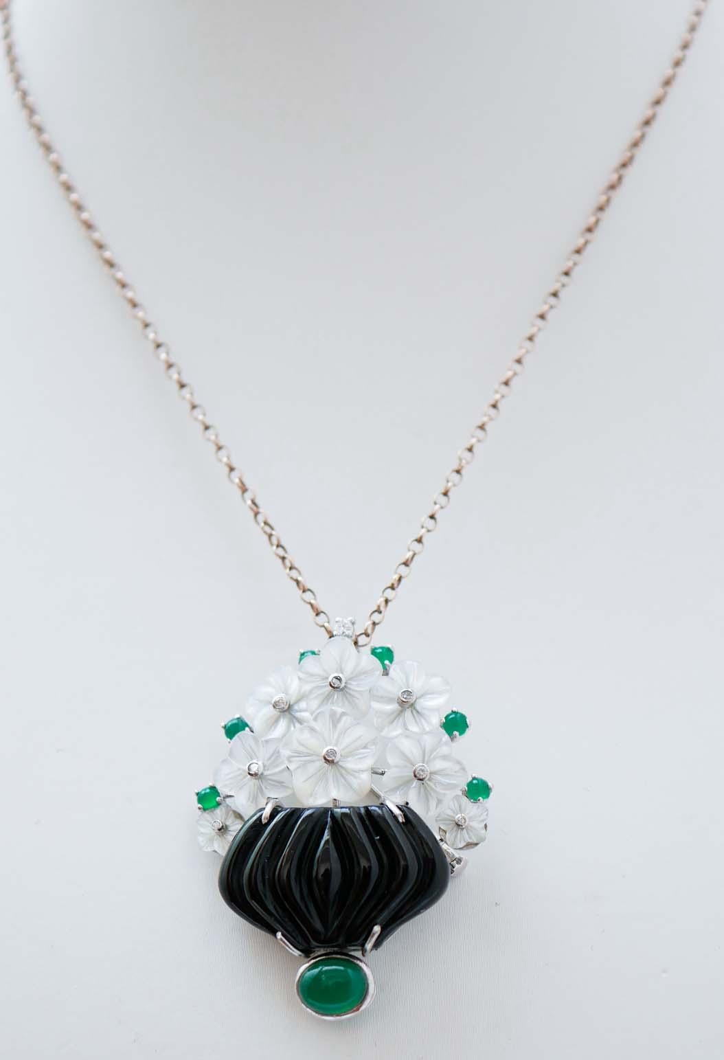 Fantastic basket brooch in platinum and 18 kt white gold structure mounted with flowers of white stones with a diamond. Between of them, green agate and below, an onyx with a green agate.
The brooch will come with a rubber chain.
This brooch was