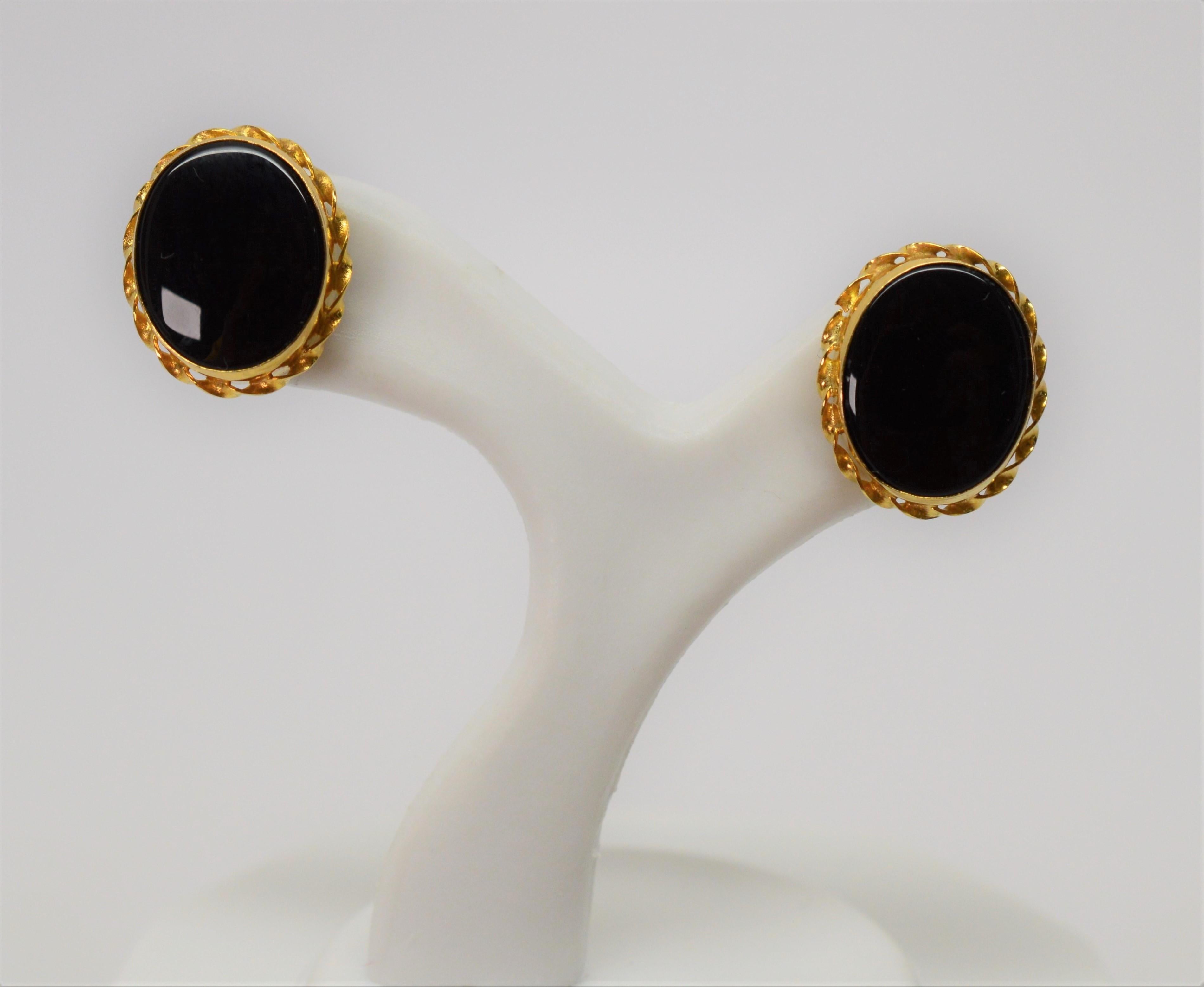 Make a subtle statement when wearing these elegant stud earrings. Highly polished 10.5 mm x 8mm oval onyx cabochons are bezel set and framed with a fancy fluted edge detail in fourteen karat 14K yellow gold. Overall measurement is 9.8 x 11.6 mm 