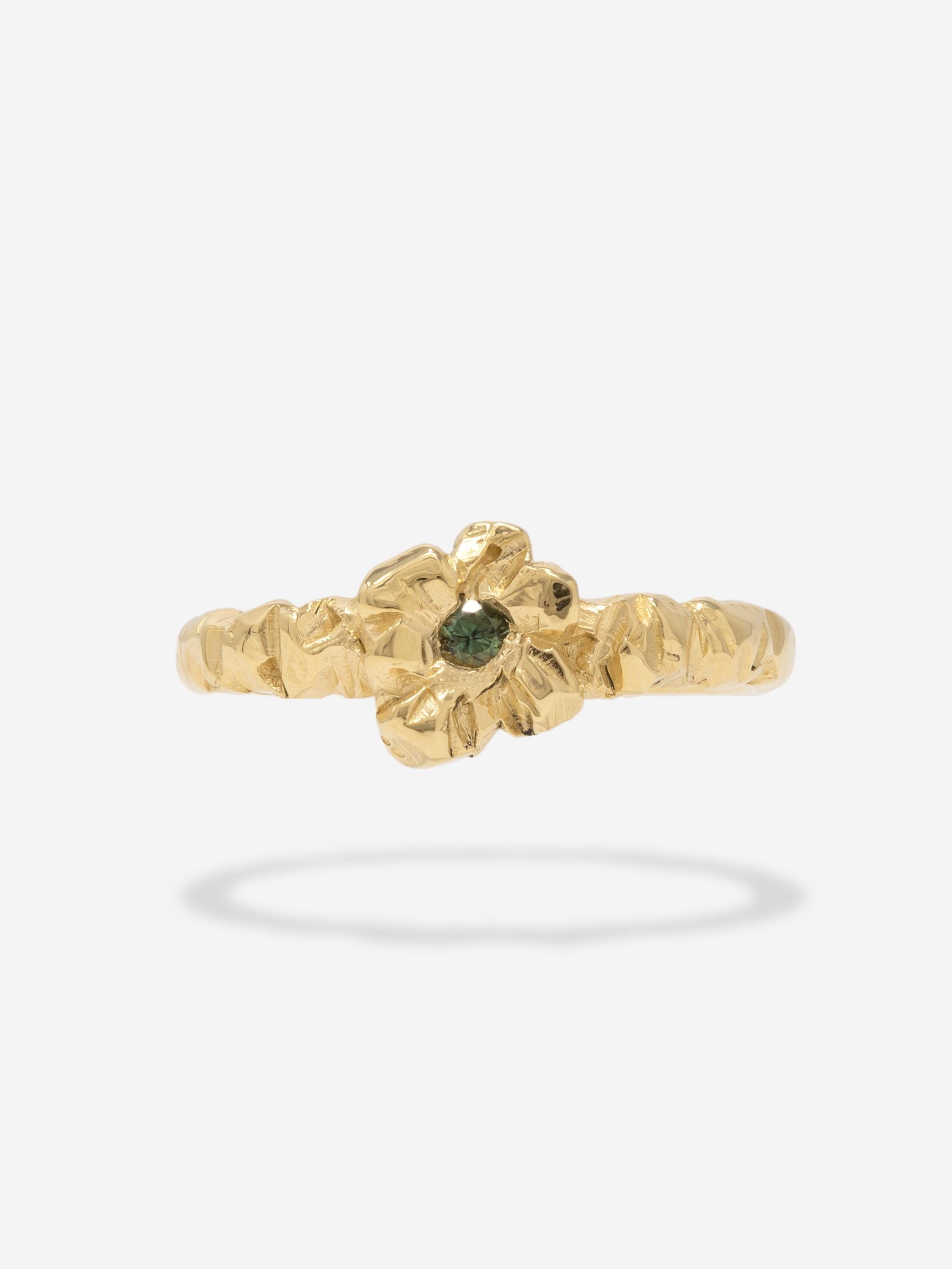 CAPTIVE - A one-of-a-kind hand carved ring cast in solid 18k gold and set with a 2.5mm Montana sapphire. The ring features Captive's distinctive Ruin texture shaped in a floral setting.
