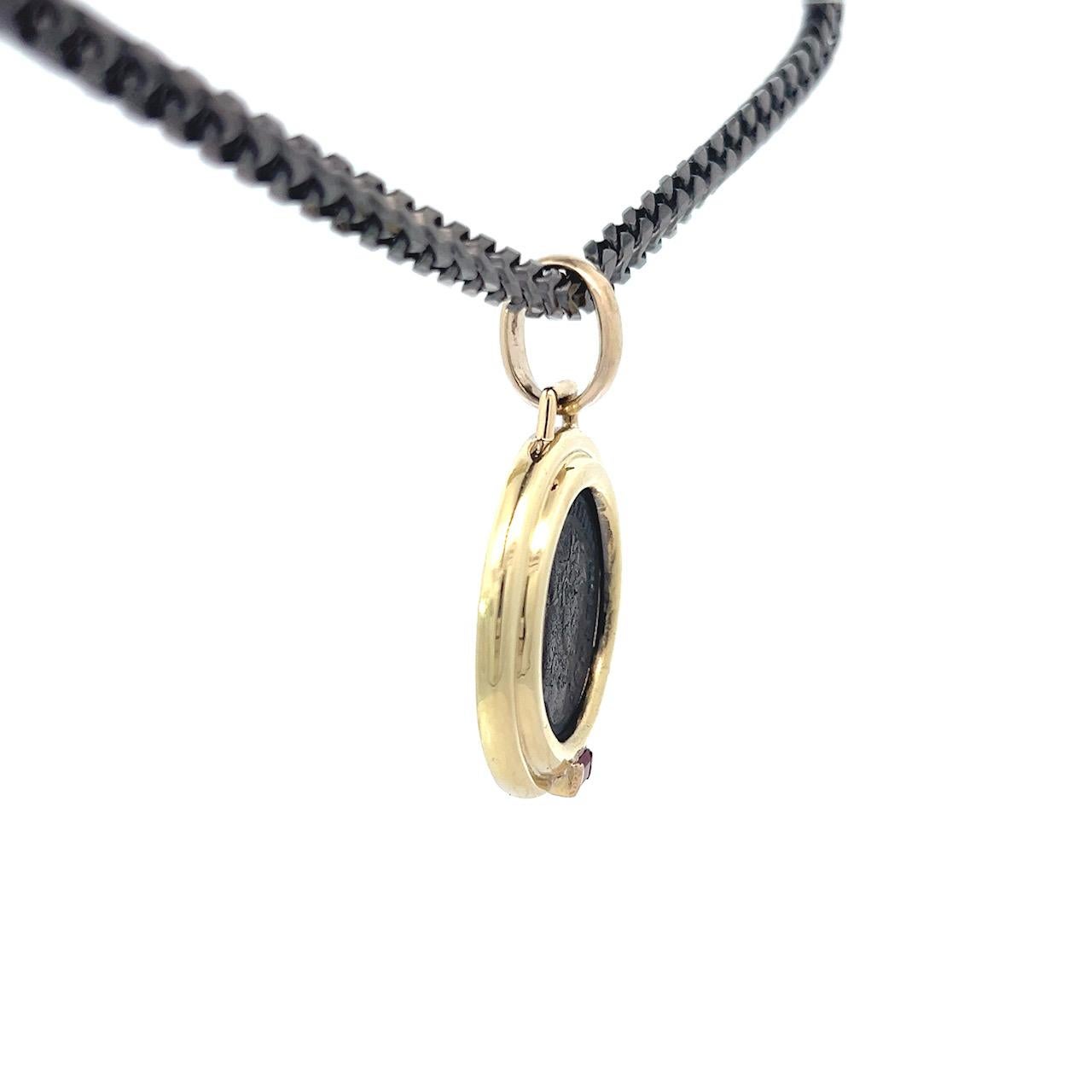 Cet exquis pendentif unique en son genre (OOAK) présente une authentique pièce de bronze de l'Antiquité romaine représentant Maximinus II AE Follis, sertie dans un luxueux double chaton en or jaune 18 carats. Le riche ton d'or de la lunette