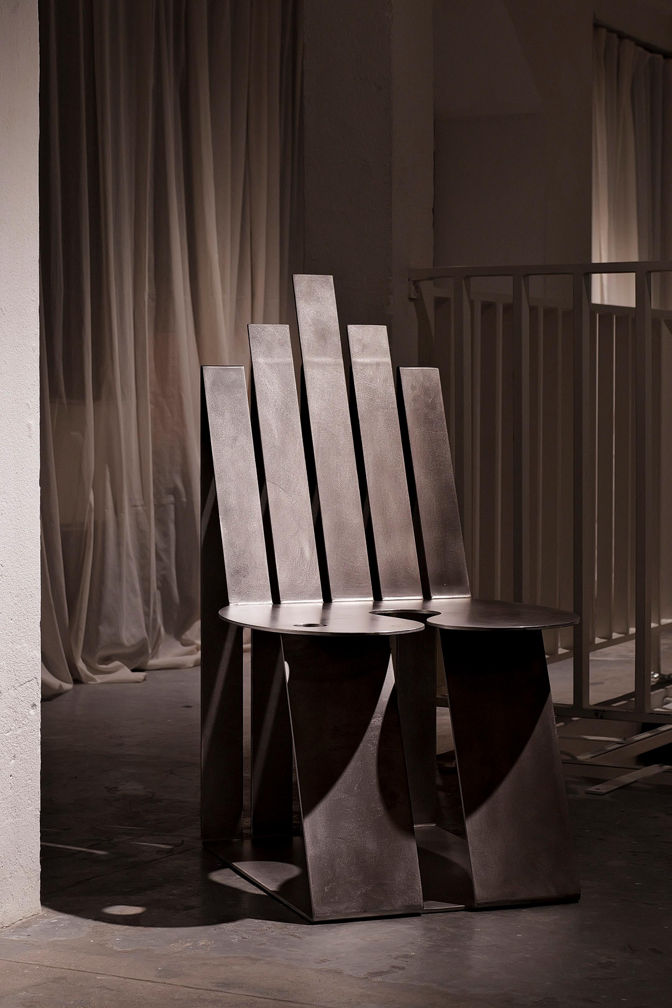 La sedia Studio A di Kiki Goti, o OO+II Stacking Chairs, è una seduta adattabile e multifunzionale composta da due sedie separate che possono essere impilate. L'utente può scegliere tra una sedia compatta, due sedie diverse (un seggiolone e uno