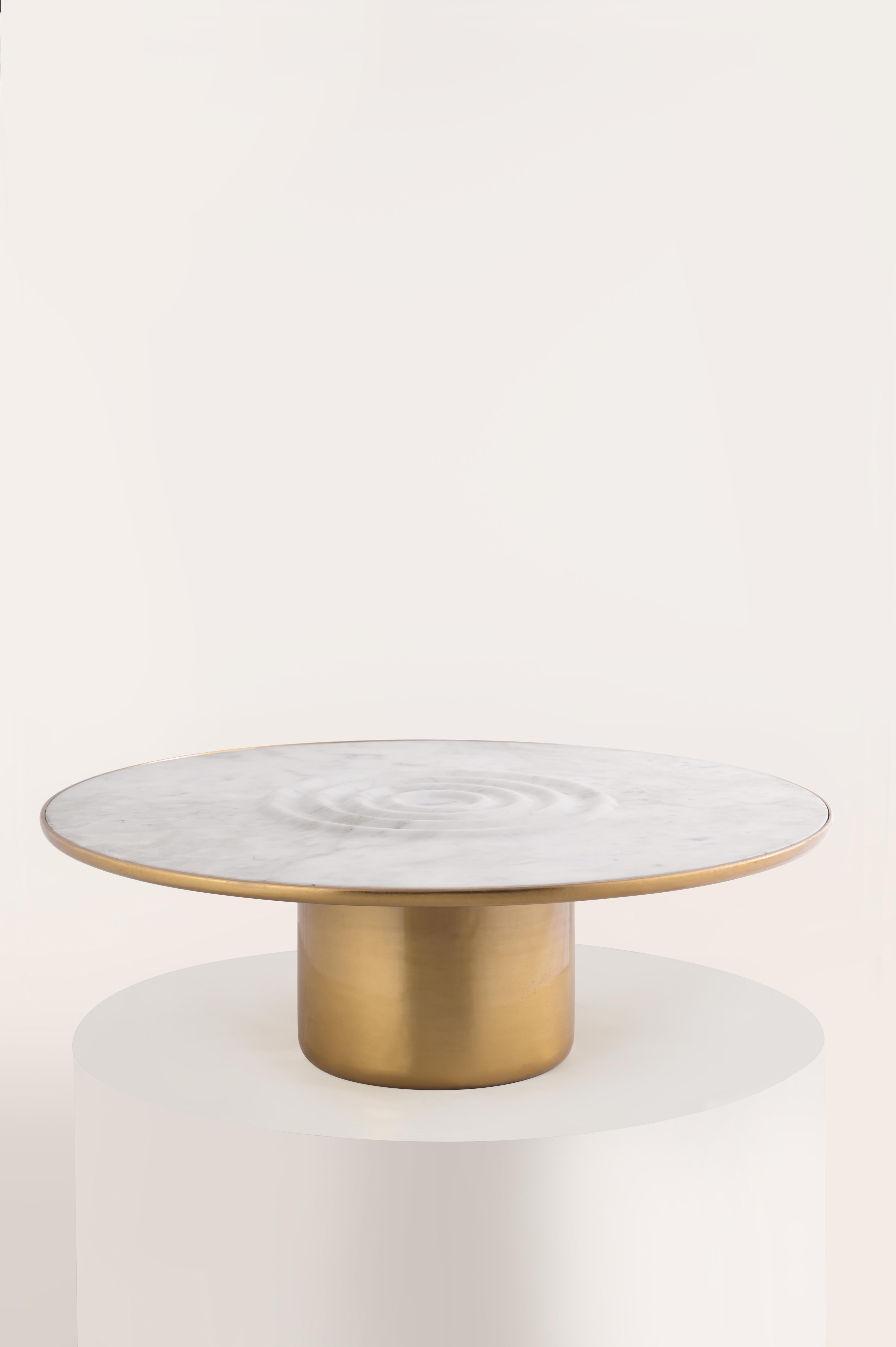 Transport your living spaces into a serene realm with our Oom Coffee Table. Crafted in marble and cast metal, it seamlessly brings the calming essence of water into your home. Inspired by the rhythmic phenomenon of ripples, this table captures not