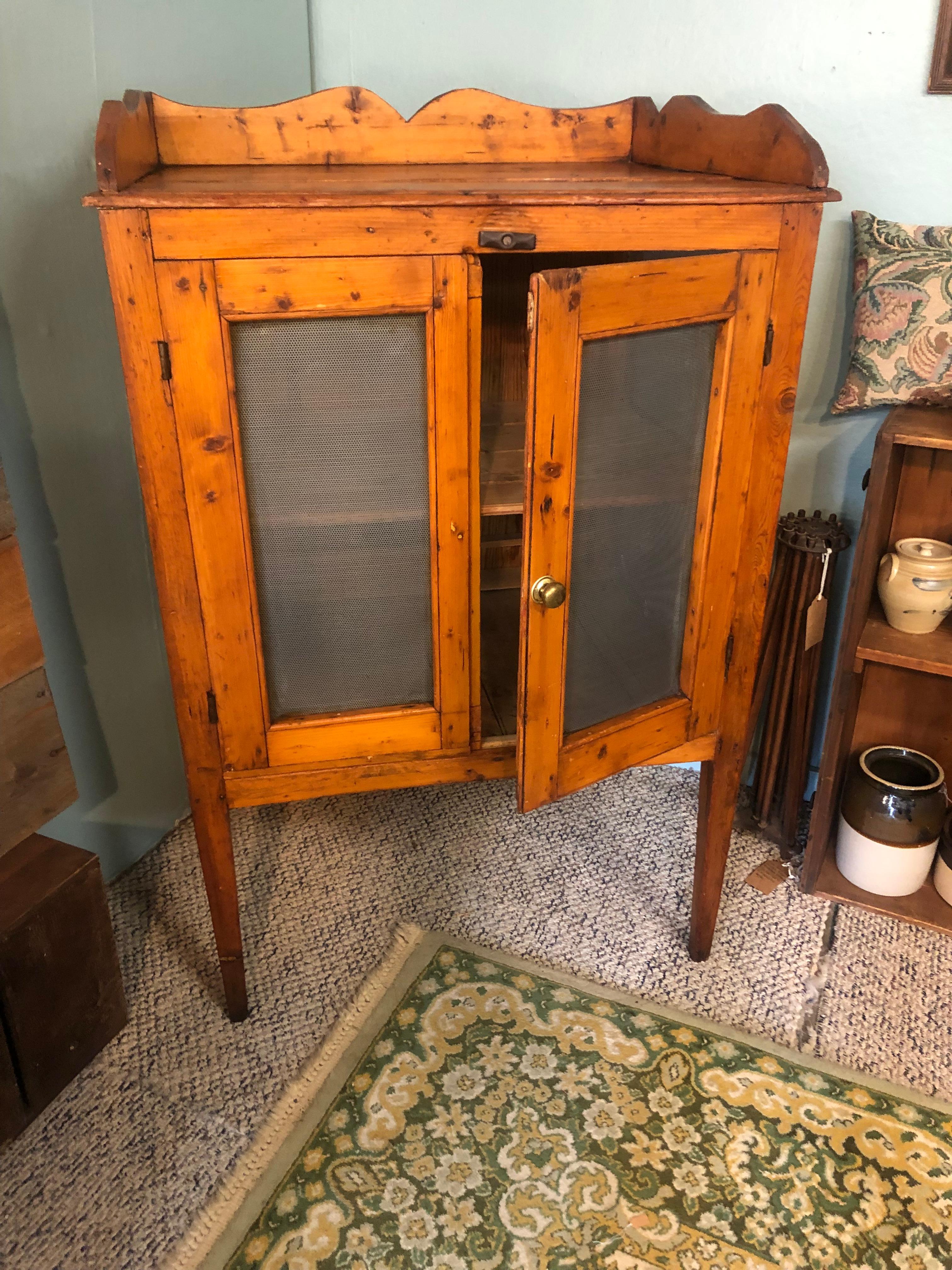 Authentic and oozing with character, a 19th century American Baltic Pine pie safe with gorgeous patina having scalloped top and original wire netting on front doors and sides. There are two shelves; bottom shelf to top 14