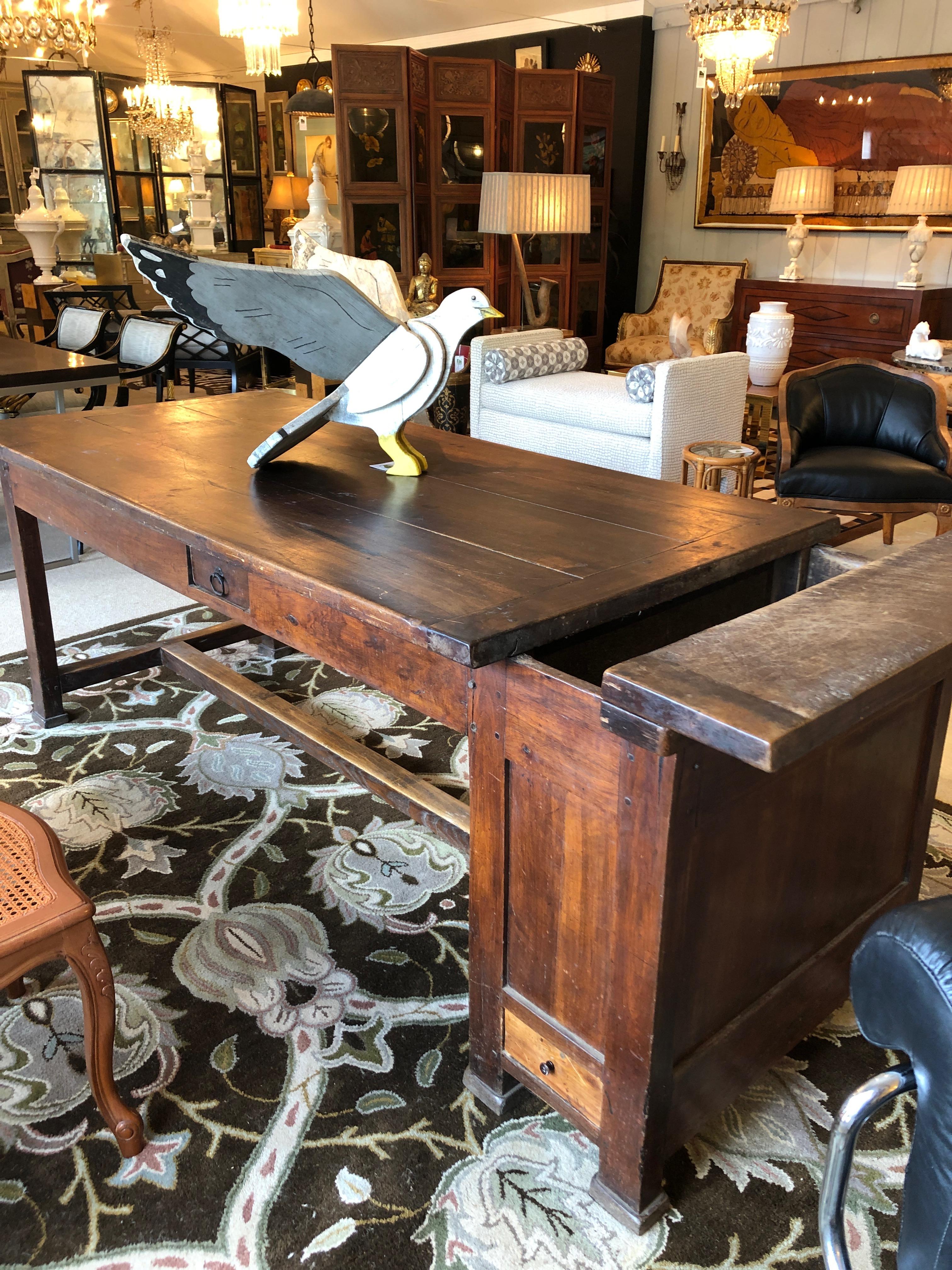 The farm table everyone admires for its unbelievable charm and character. It's a heavy 19th century walnut import from the French countryside, having a wooden plank top with baguette opening at one end as well as 4 drawers, including one the width