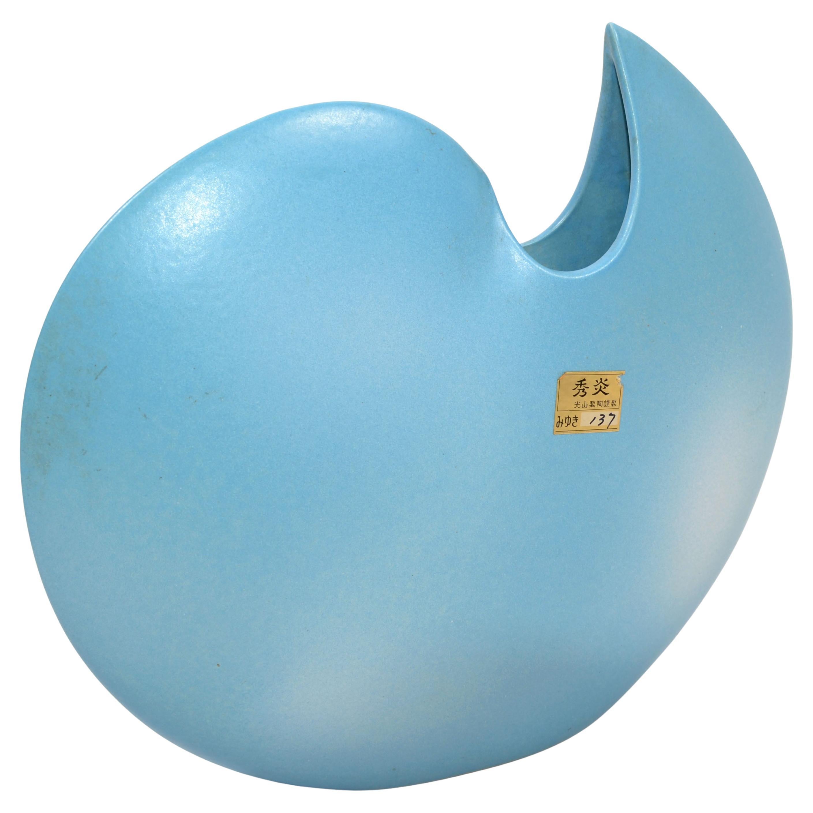 Stunning Mid-Century Modern round and flat Japan baby blue and white ceramic vase with a Sculptural opening.
Original gold foil mark at the vase.
Beautiful Object d' Arte for display or Centerpiece on Your festive Table Settings.

A-417-335