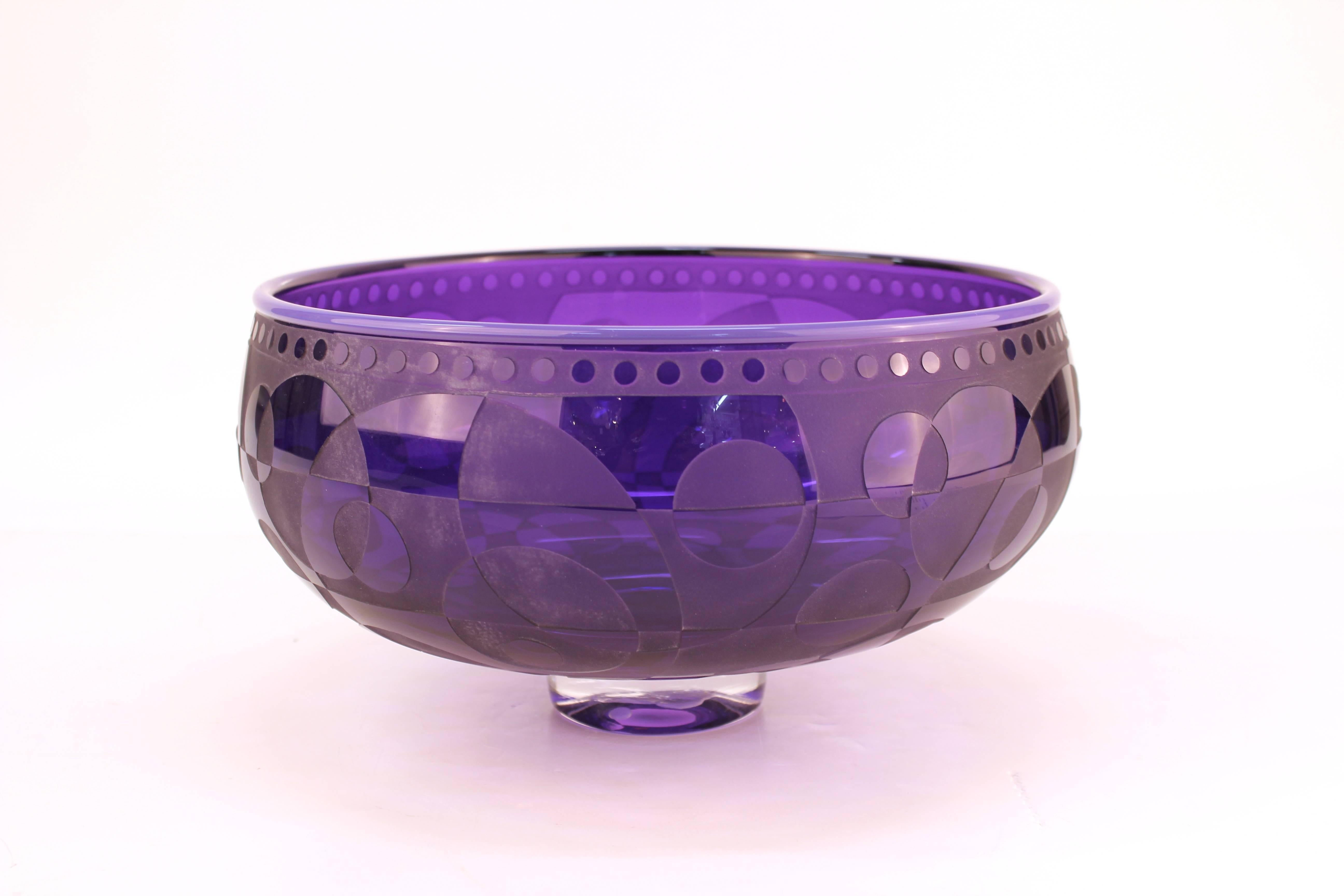 Etched purple art glass studio bowl in op-art style, signed and dated illegibly on the lower band. The piece has a striking motif of intersected circles and geometric shapes. In good vintage condition.