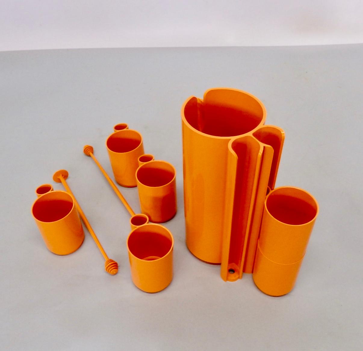 Modular op pop orange plastic drinks set. Six cups stacked three each on either side. Pair of stir sticks slip into stacked cup handles. Very nice piece of modern era design. Marked Made in France Depose.