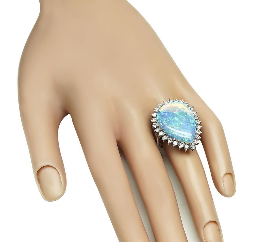 Dies ist ein eleganter Ring aus 14 Karat Weißgold. Der Ring ist mit schönen Birne Form Opal zentriert. Der Mittelstein wird durch funkelnde, rund geschliffene Diamanten mit einem Gewicht von ca. 1.50 ct akzentuiert. Die Farbe dieser Diamanten ist G
