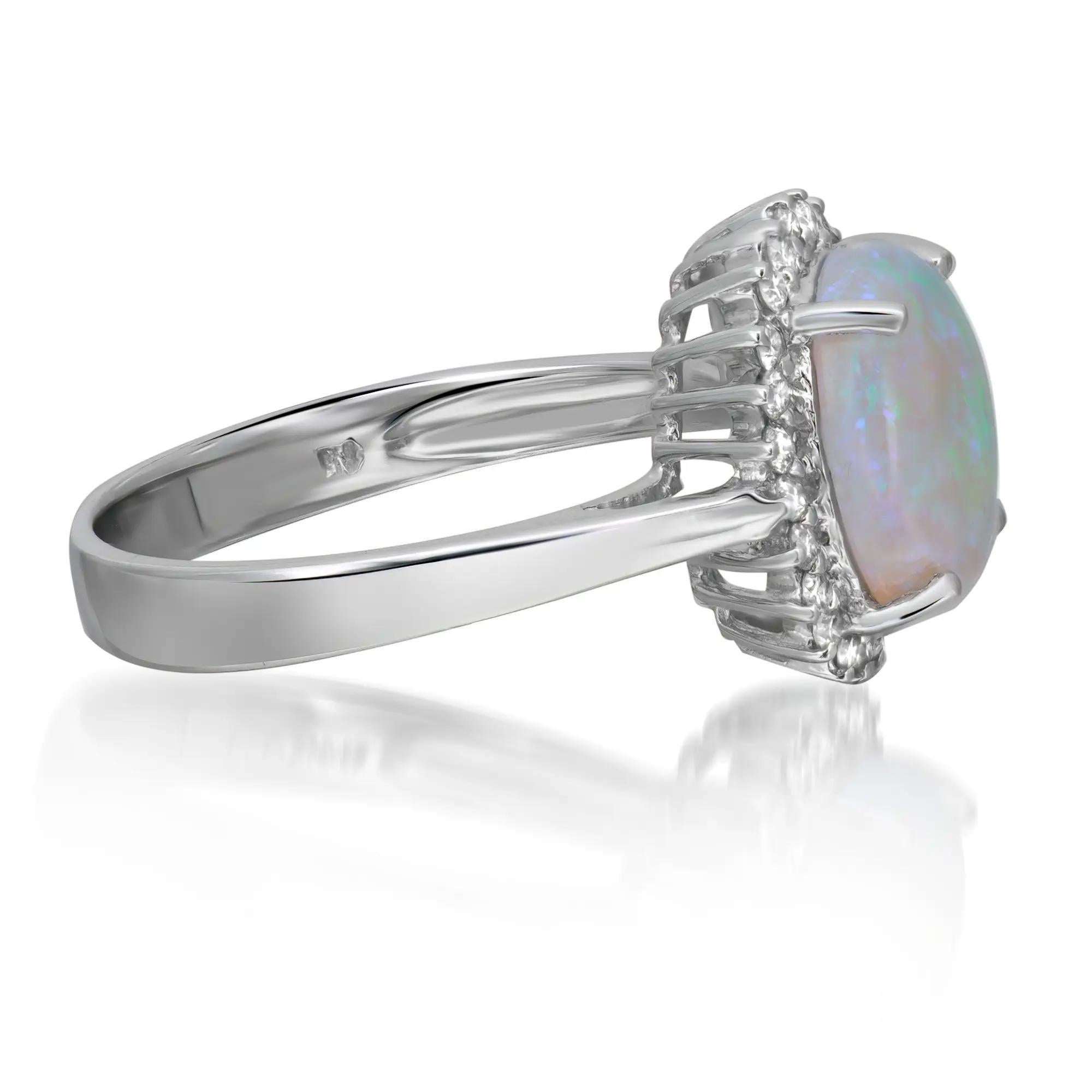 Este precioso anillo de cóctel está elaborado en lustroso oro blanco de 14 quilates. El ópalo blanco ovalado engastado en el centro, de 1,80 quilates, brilla con matices multicolores y está rodeado por un halo resplandeciente de diamantes talla