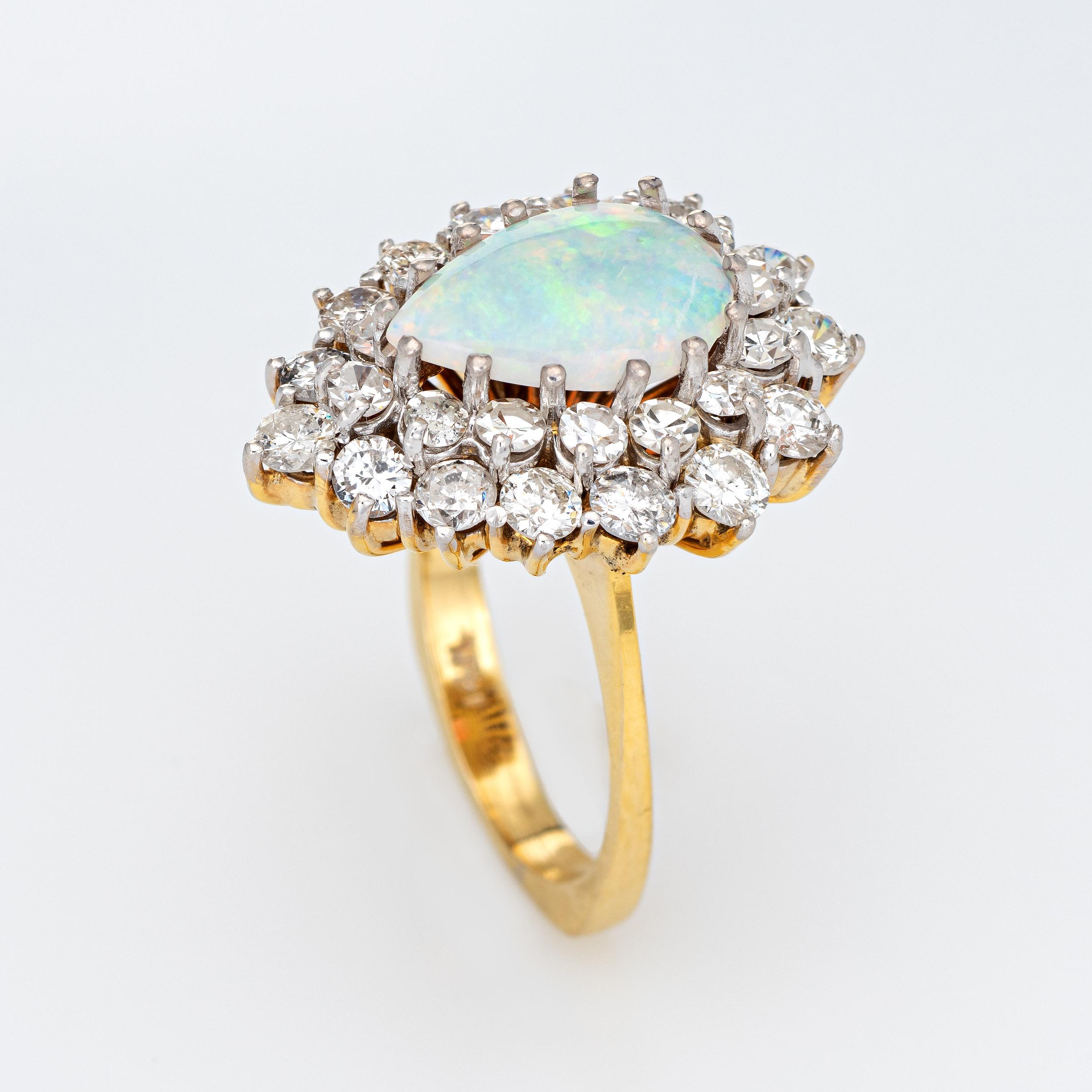 Stylish opal & diamond ring (circa 1980s to 1990s) crafted in 14k yellow gold. 

Natural opal measures 11mm x 8mm (estimated at 1.50 carats), accented with an estimated 2 carats of round brilliant cut diamonds. The diamonds are estimated at H-I