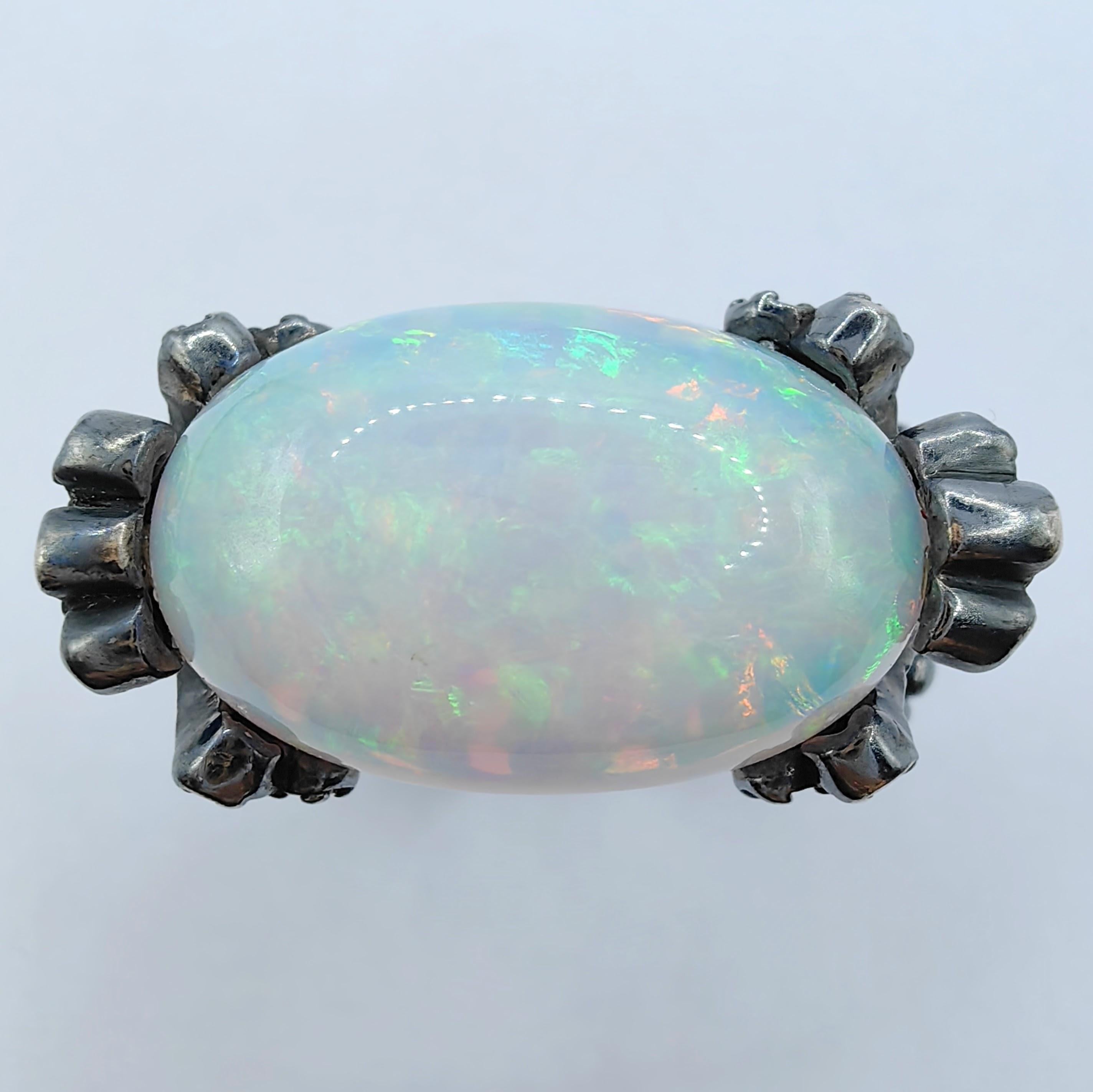 Entdecken Sie den exquisiten Cocktail-Statement-Ring mit Opal, Saphir und Diamant aus Sterlingsilber, eine fesselnde Verschmelzung von Edelsteinen und Kunstfertigkeit, die einen orientalischen Charme ausstrahlt. Dieses bemerkenswerte Stück zeigt