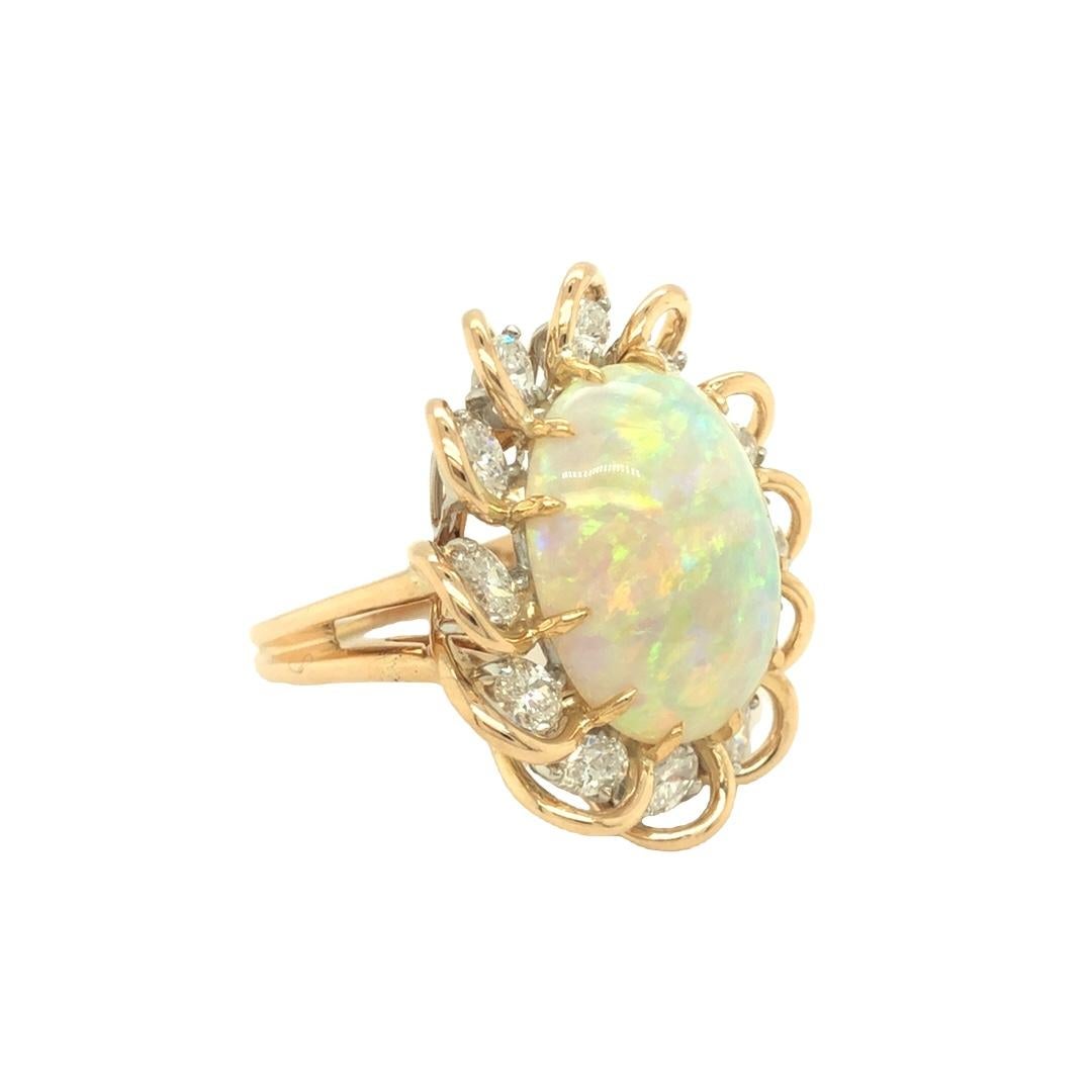  Artfully designed and inspired by nature, this beautiful opal is encircled by 12 oval cut diamonds weighing approximately 2.40 carats total. High polished gold wire wraps around each diamond resembling flower petals. The ring is rendered in 18K