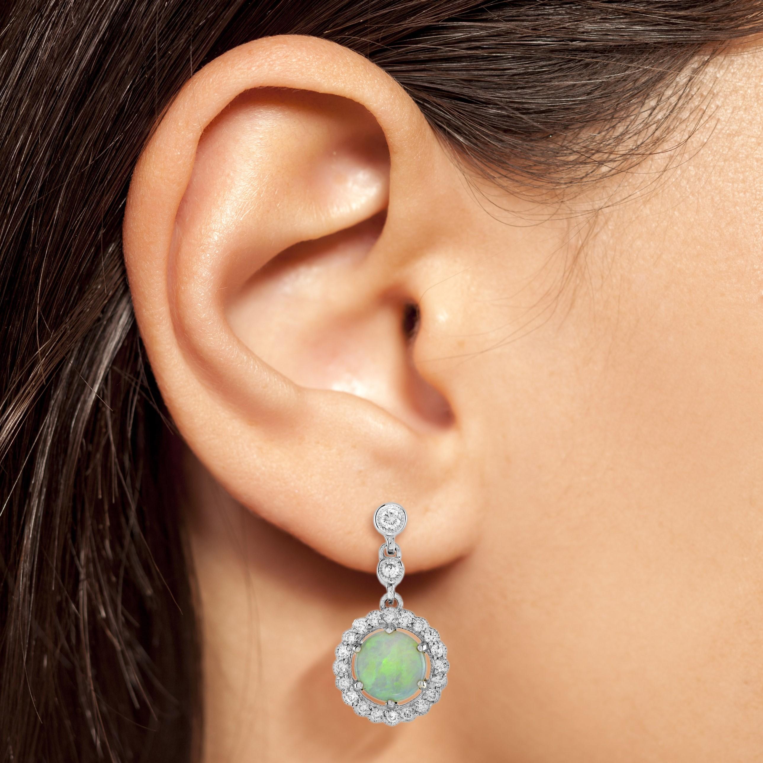 Boucles d'oreilles Halo en Opale et Diamant de style Art Déco, cette élégante paire de boucles d'oreilles de style Art Déco est ornée d'une superbe opale ronde au centre, dont le jeu de couleurs vibrantes ajoute une touche de mysticisme et d'allure.