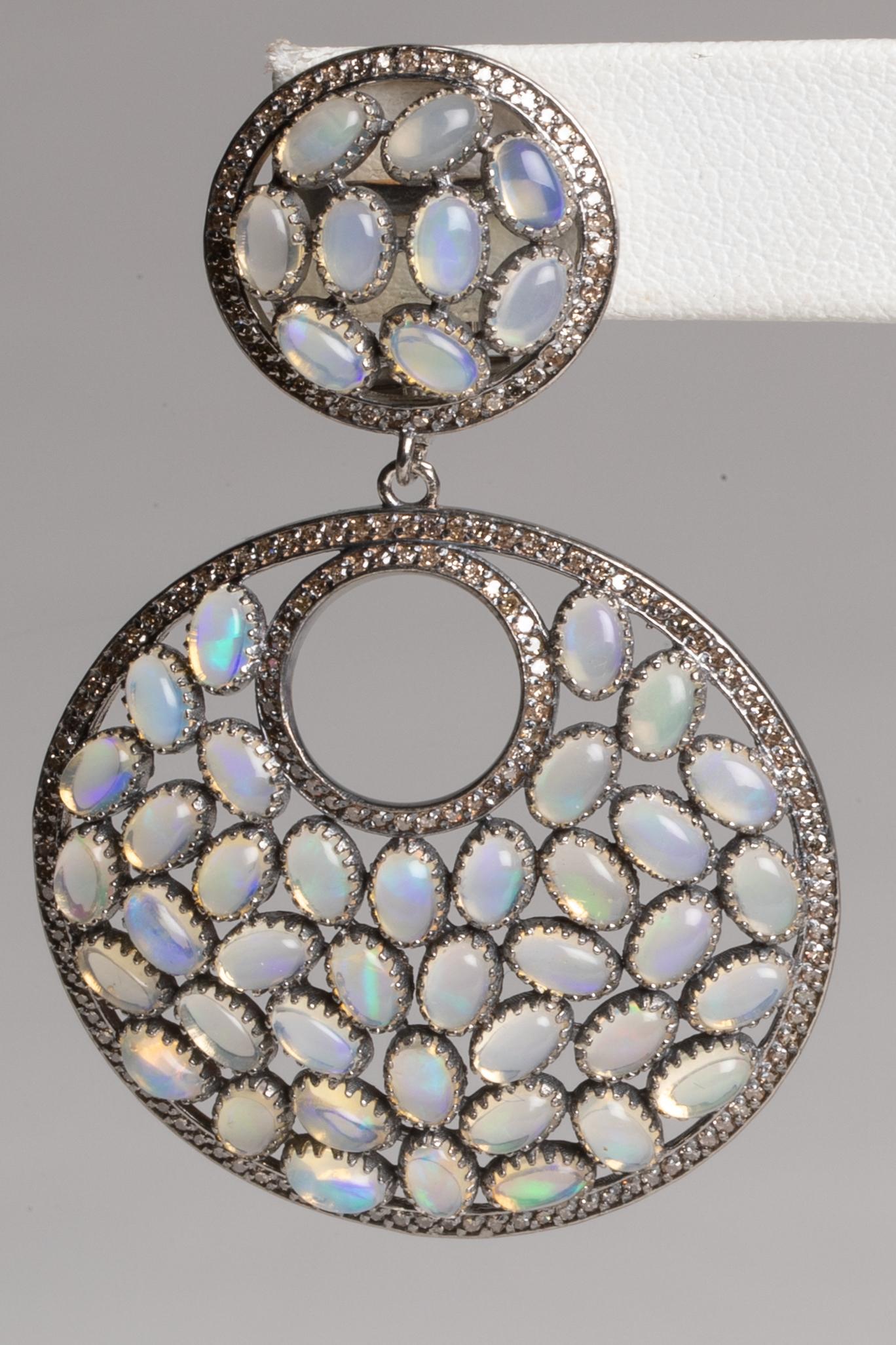 Fire-y, oval-shaped opals in a bezel sterling silver setting bordered with pave'-set round diamonds.  18K gold post for pierced ears.  Weight of opals is 13.85 carats, diamonds are 1.81 carats.  The photos on the model show the earrings a bit more