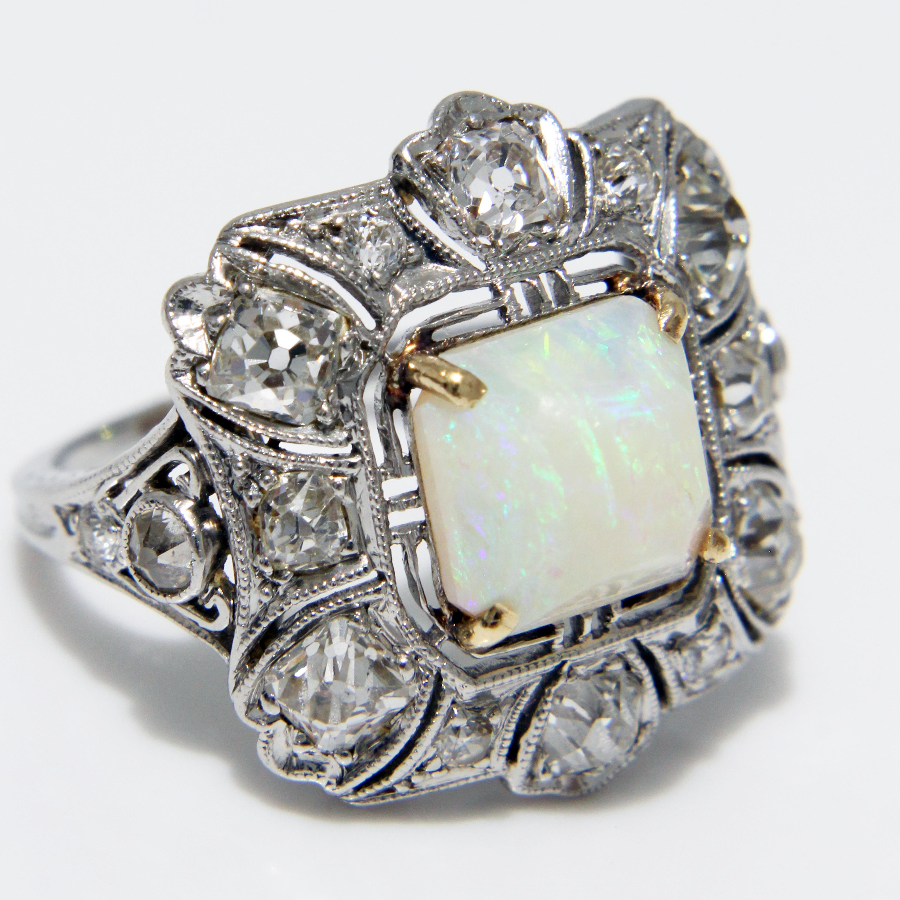 Preowned vintage/antique Art Deco style opal and diamond cocktail ring, likely made in the early 20th C.  Made from a platinum setting, it features one large square opal surrounded by 16 round diamonds.  A stunning and unique fine jewelry piece