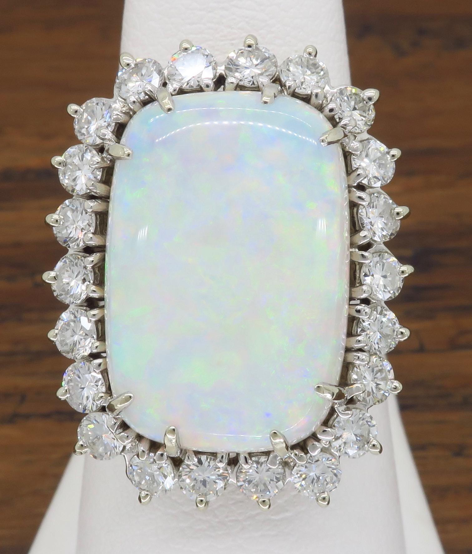 This beautiful opal cocktail ring shows a vivid play of iridescent colors surrounded by 22 Round Brilliant Cut Diamonds. 

Gemstone: Opal & Diamond
Gemstone Carat Weight: Approximately 19x13.2mm Opal
Diamond Carat Weight: Approximately