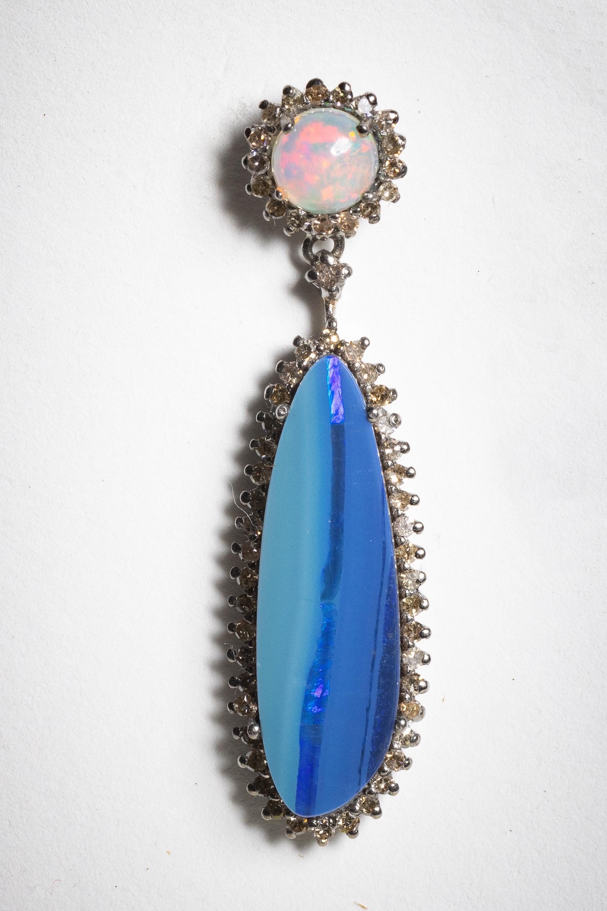 A lovely mix of opals, a round Brazilian opal at the post with round brilliant cut diamonds on the border;  The drop is an Owhyee opal also surrounded by faceted diamonds.  Set in an oxidized sterling silver with 18K gold posts for pierced ears. 
