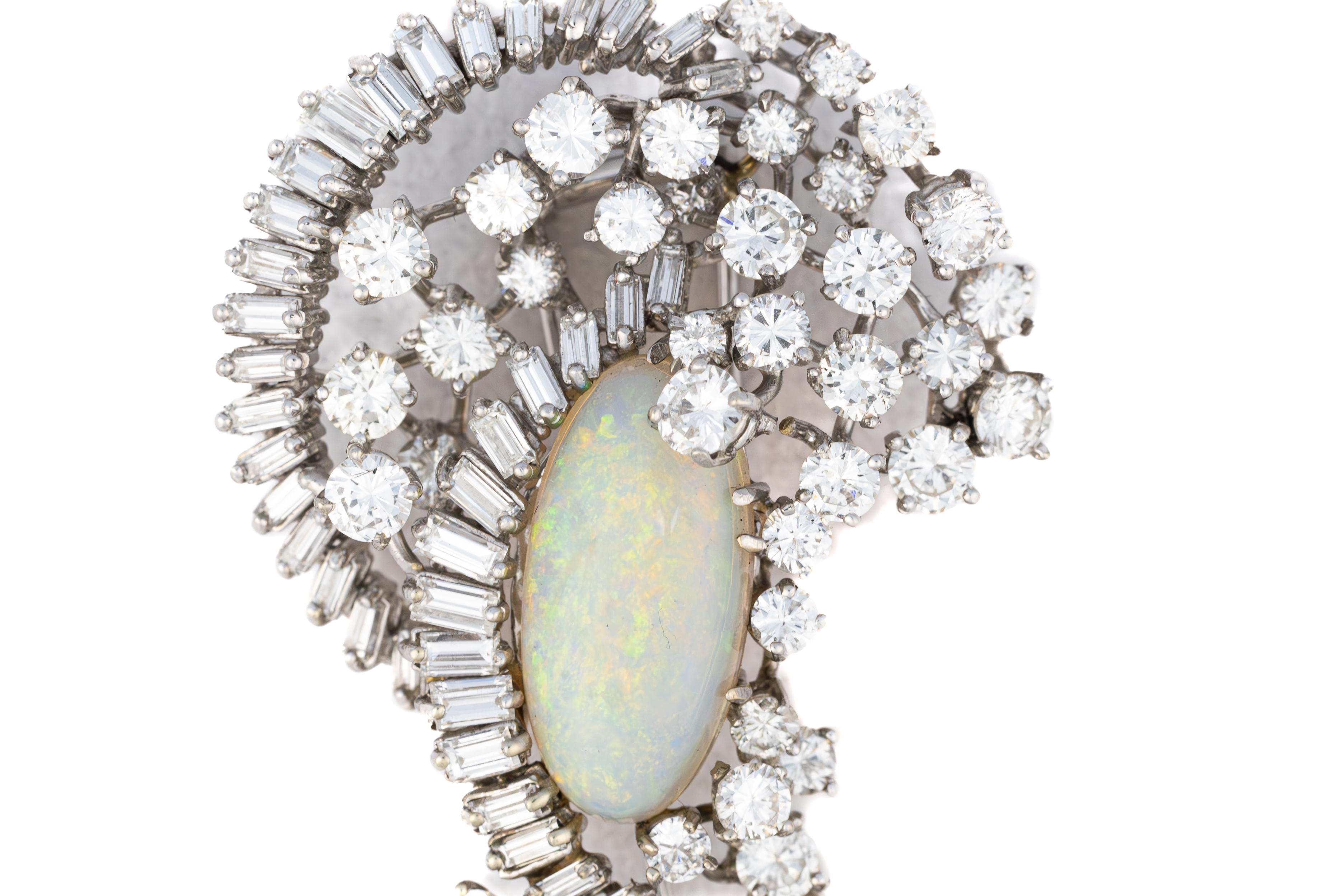 Opal and Diamond Platinum Brooch

Description: A breathtaking display of elegance, this opulent brooch is a true masterpiece of design, featuring a mesmerizing opal drop weighing approximately 26.32 carats. Above it, an oval-cut opal of