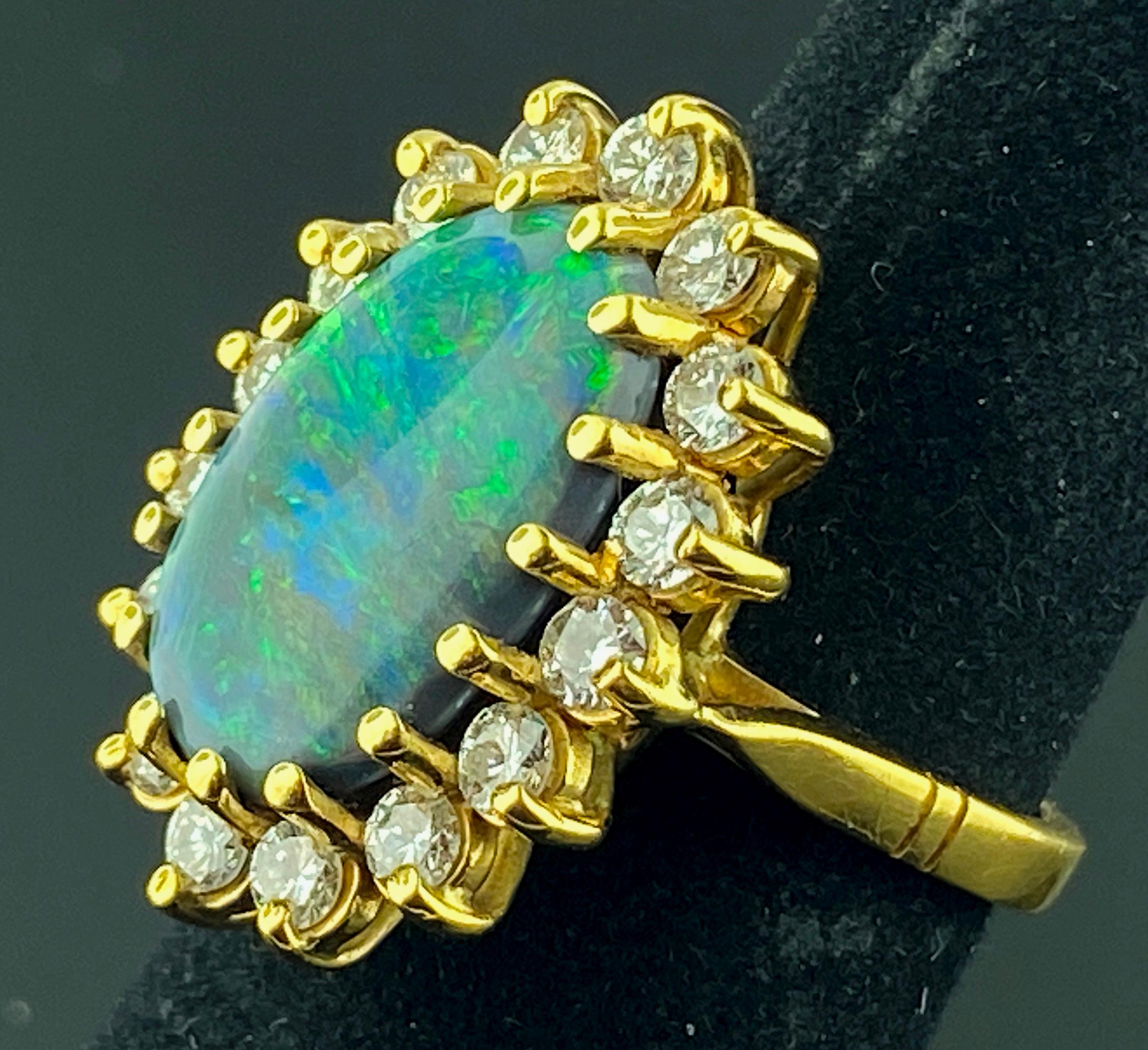 Set in 18 karat yellow gold is a 10 x 16 millimeter Opal surrounded by 17 round brilliant cut diamonds with a total diamond weight of 2.00 carats.  Color is G, Clarity is VS.  Ring size is 7.