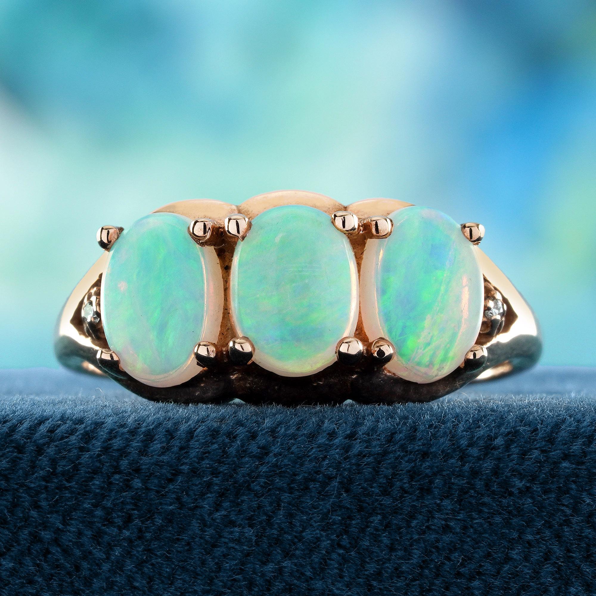 A mesmerizing trio of opals are arranged in a stunning three-stone design, enhanced by sparkling diamonds that bring additional shine and brilliance. The opal’s captivating play of colors creates a unique and ethereal beauty, while the diamonds