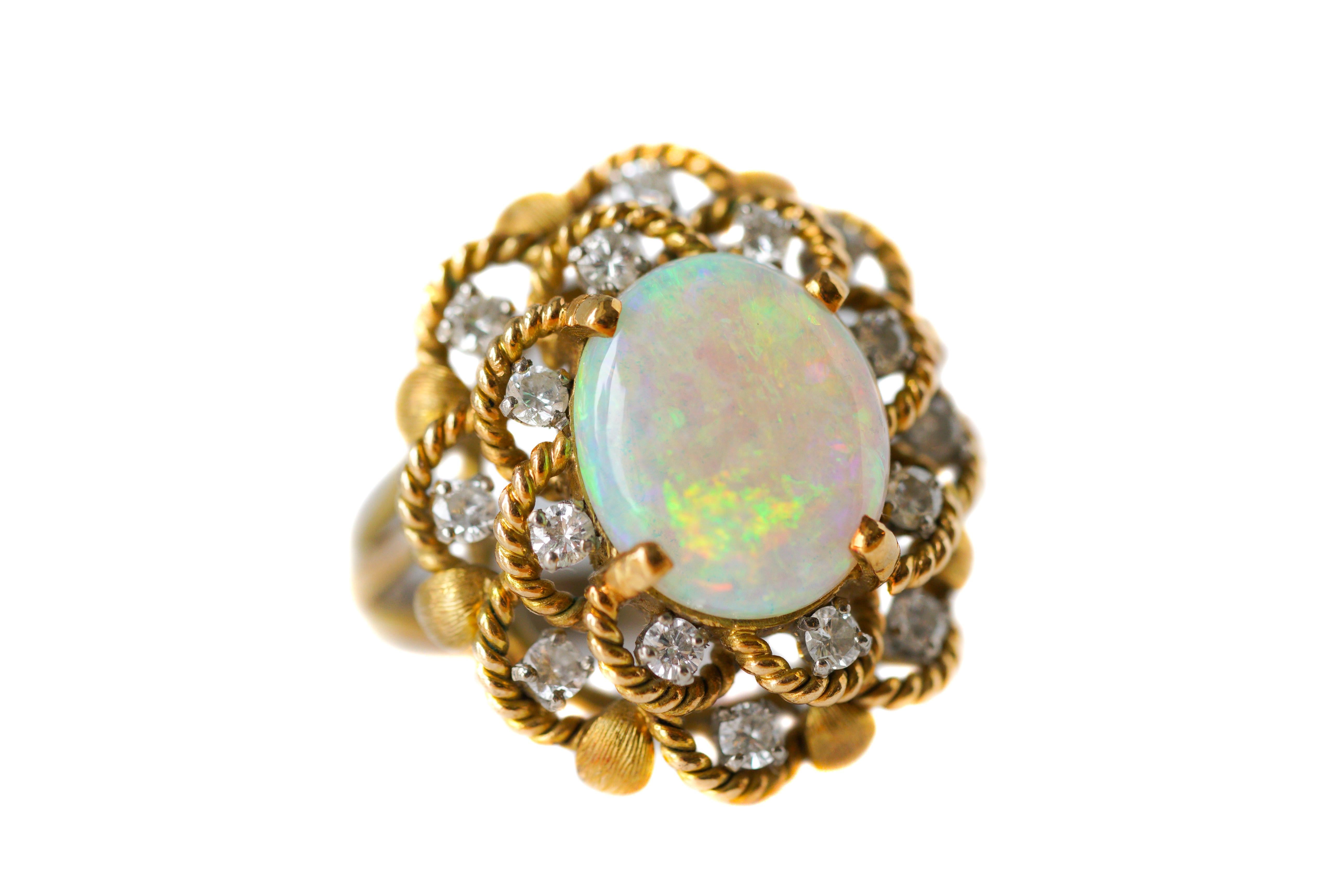 This stunning Victorian Era Ring features an Oval Opal Center Stone and a 1.2 carat total Diamond Halo, 16 Diamonds Total. 

The beautiful gemstones are prong-set in a Floral 14 karat Yellow Gold Cathedral Setting with Open Cutout Gallery and Split