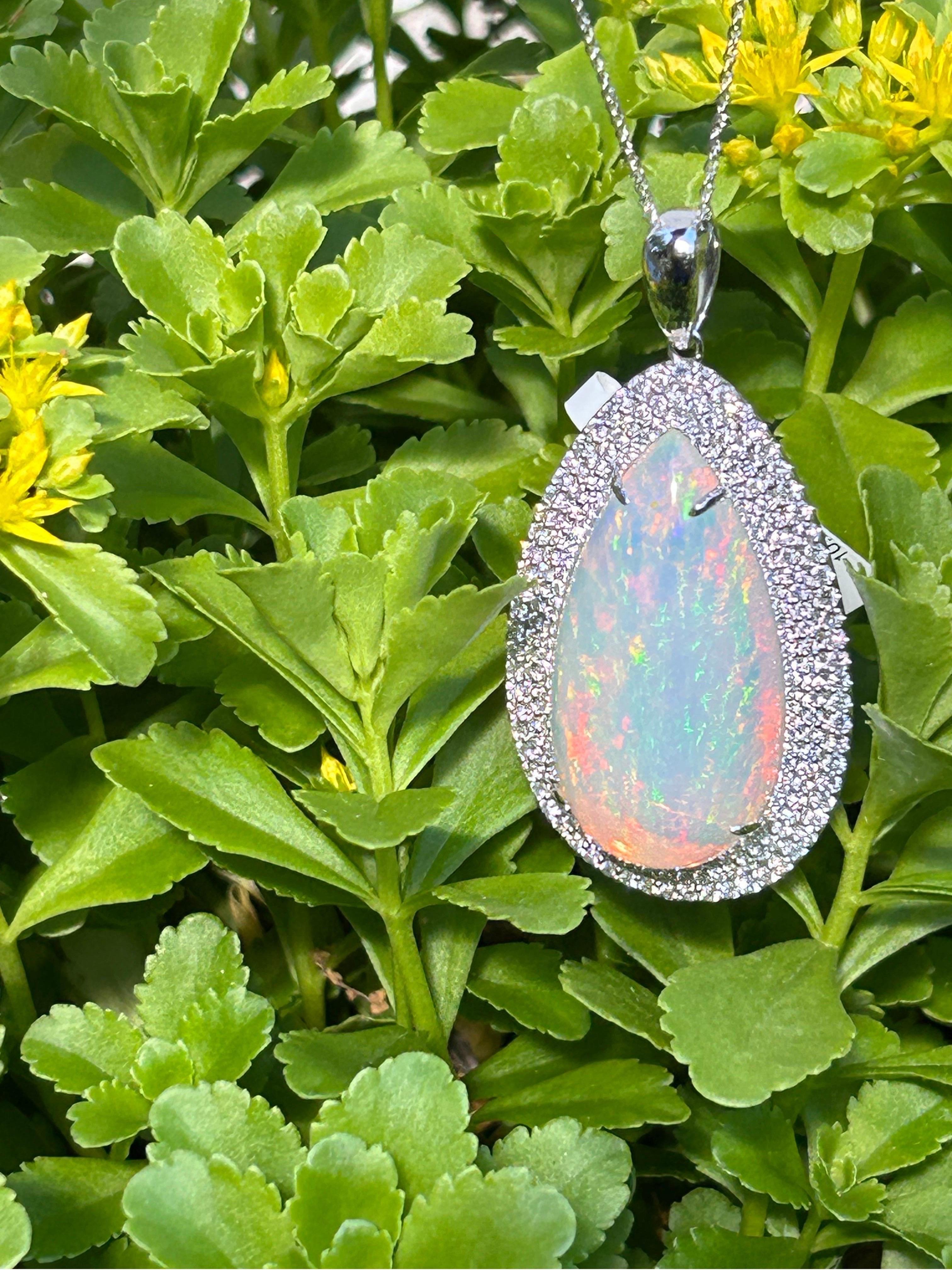 This extraordinary pendant features a colossal 49-carat pear-cut opal, showcasing magnificent fire and hand-cut and polished to perfection. The opal is elegantly framed by three rows of diamonds, totaling 2.57 carats, graded F color and VS clarity.