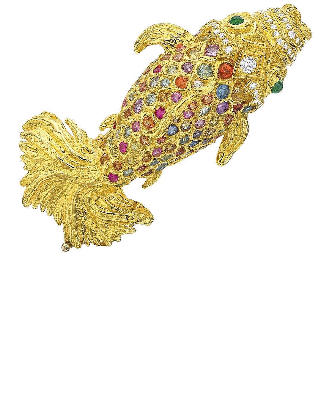 This Andrew Glassford Brooch is from his Premier Collection in 2017 and was inspired by a family piece of Jewelry worn for many years. The 18k Yellow gold brooch is a fish whose scales are comprised of 2.45 carats of Multi-Colored Fancy Sapphires.