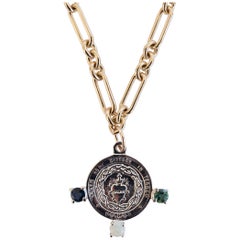 Collier à chaîne en argent et perles noires avec tourmaline bleue et verte en forme de cœur sacré.