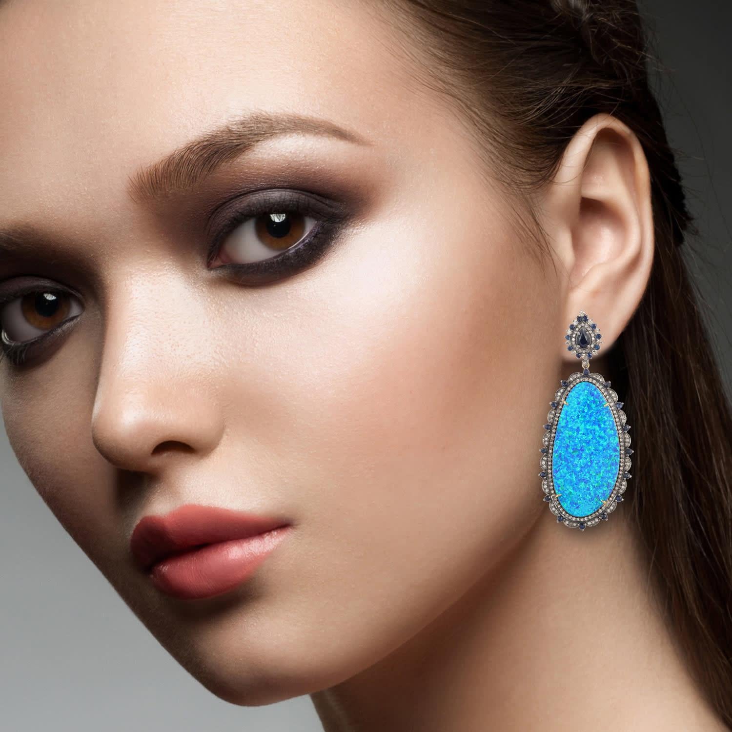 These stunning earrings are crafted in 18-karat gold and sterling silver. It is hand set in 21.38 carats opal doublets, 2.54 carats blue sapphire and 2.0 carats of diamonds. 

FOLLOW MEGHNA JEWELS storefront to view the latest collection & exclusive