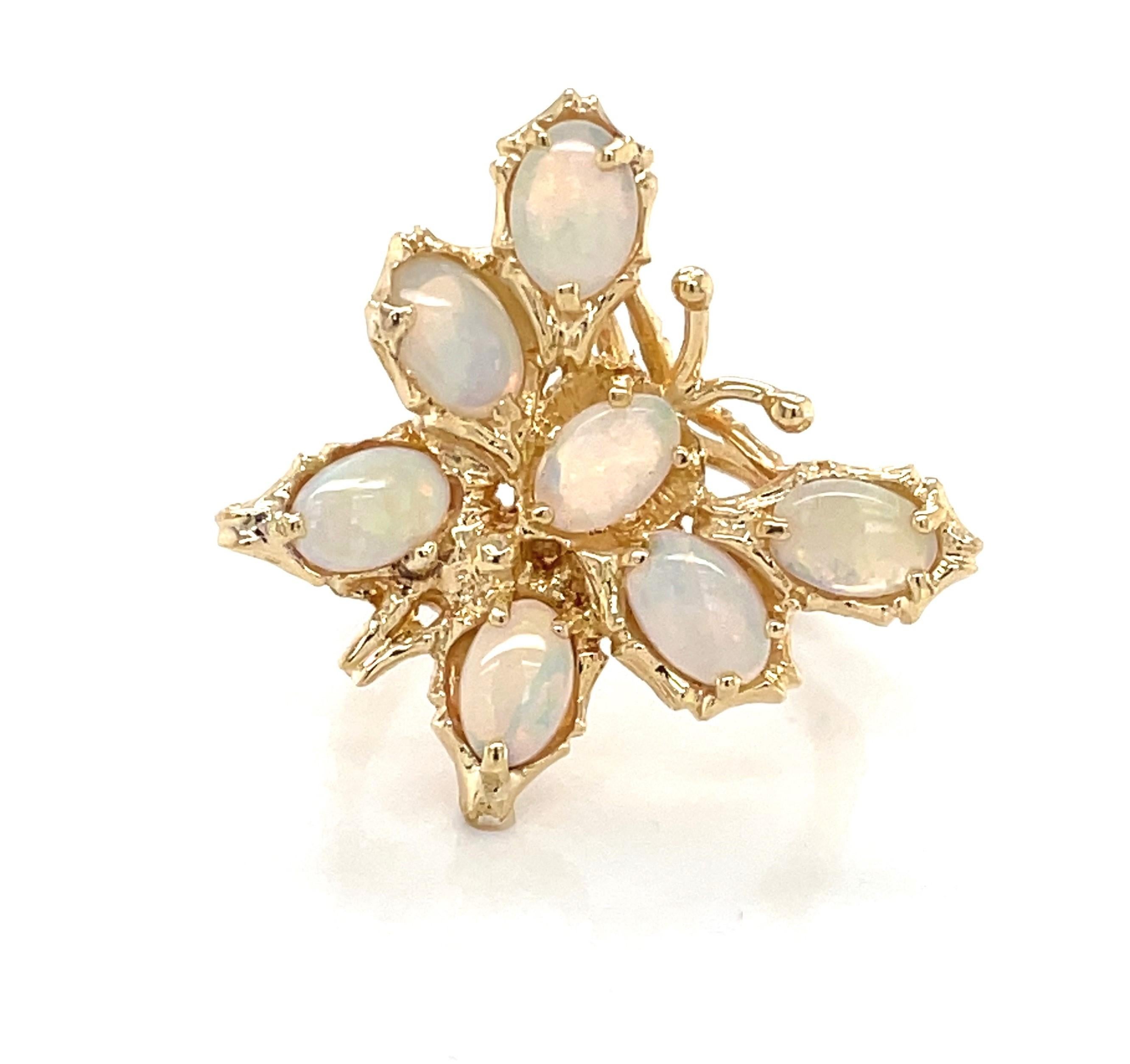 With wings of translucent opal, this whimsical butterfly ring in fourteen karat 14k yellow gold is a symbol of positivity and hope. Playfully set asymmetrically as if the butterfly was in flight, the ring is constructed with open gallery which gives