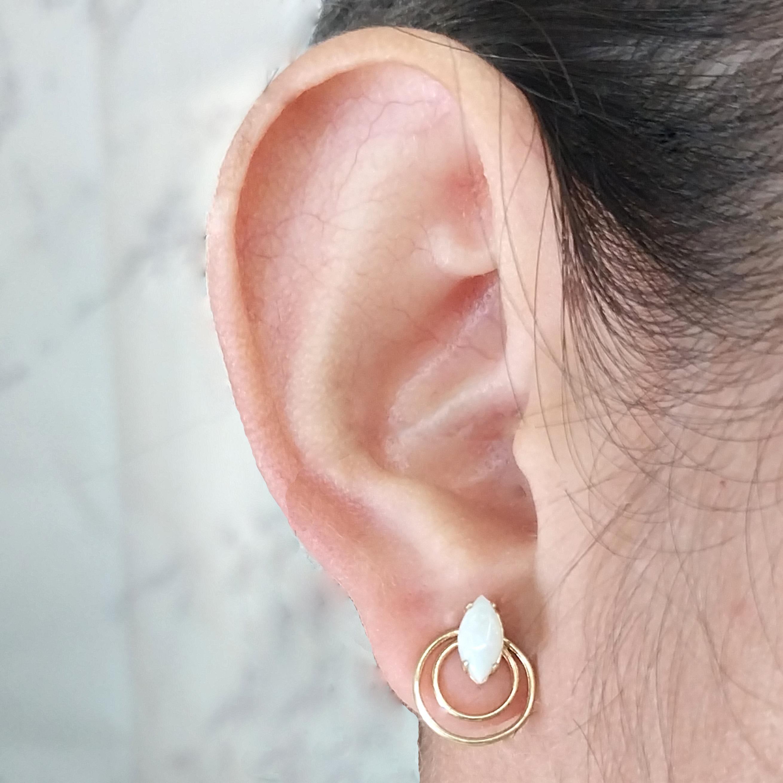 Boucles d'oreilles en or jaune 14 carats composées de deux opales précieuses taillées en marquise et rehaussées d'un anneau concentrique. Poteau percé avec dos à friction. Le poids fini est de 1,4 gramme.