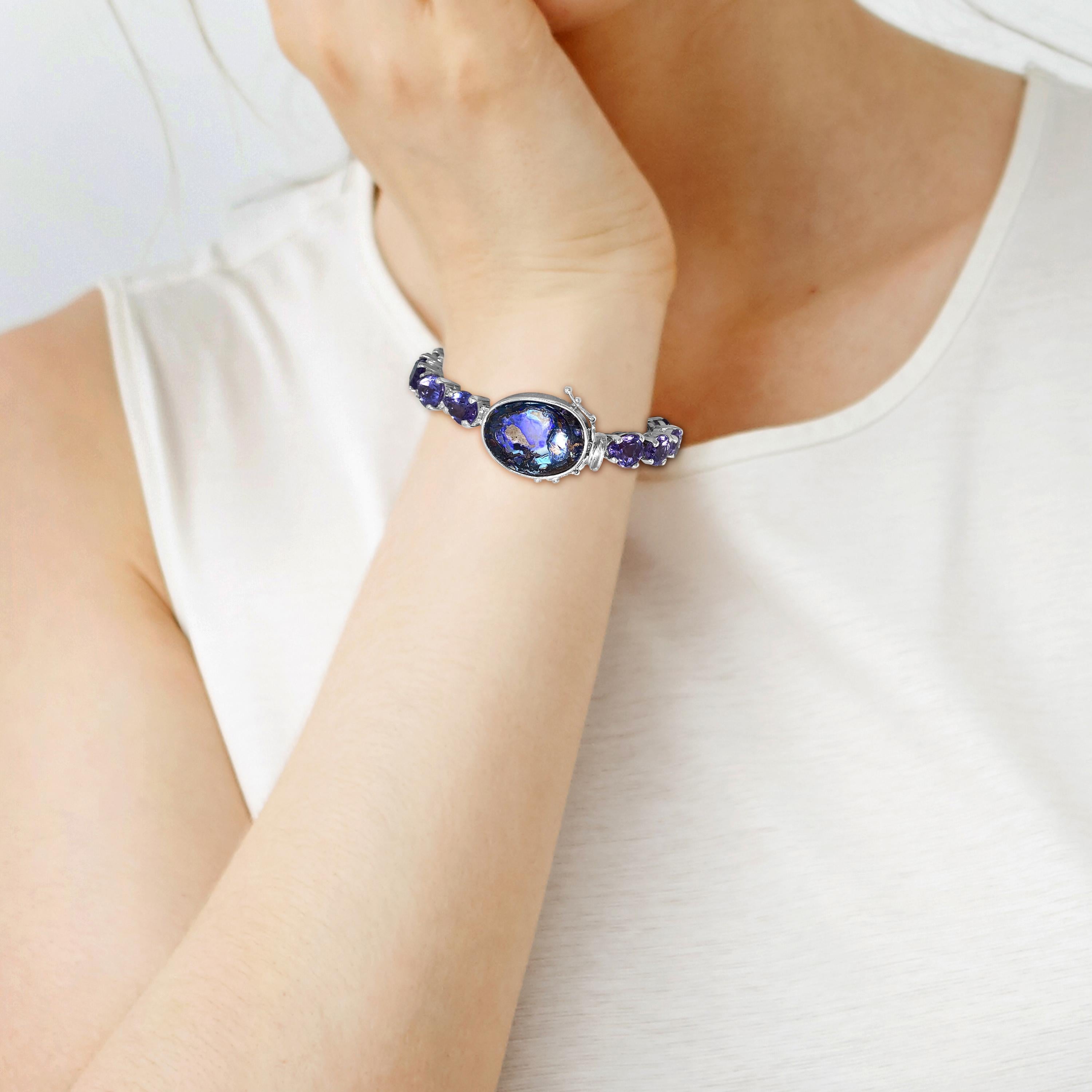 Cloak your wrist in this Artisan One of a Kind Shimmering Opal Closure Amethyst Accent Tennis Bracelet in Sterling Silver with Decorative Clasps

Bracelet Length: 7.25 in
