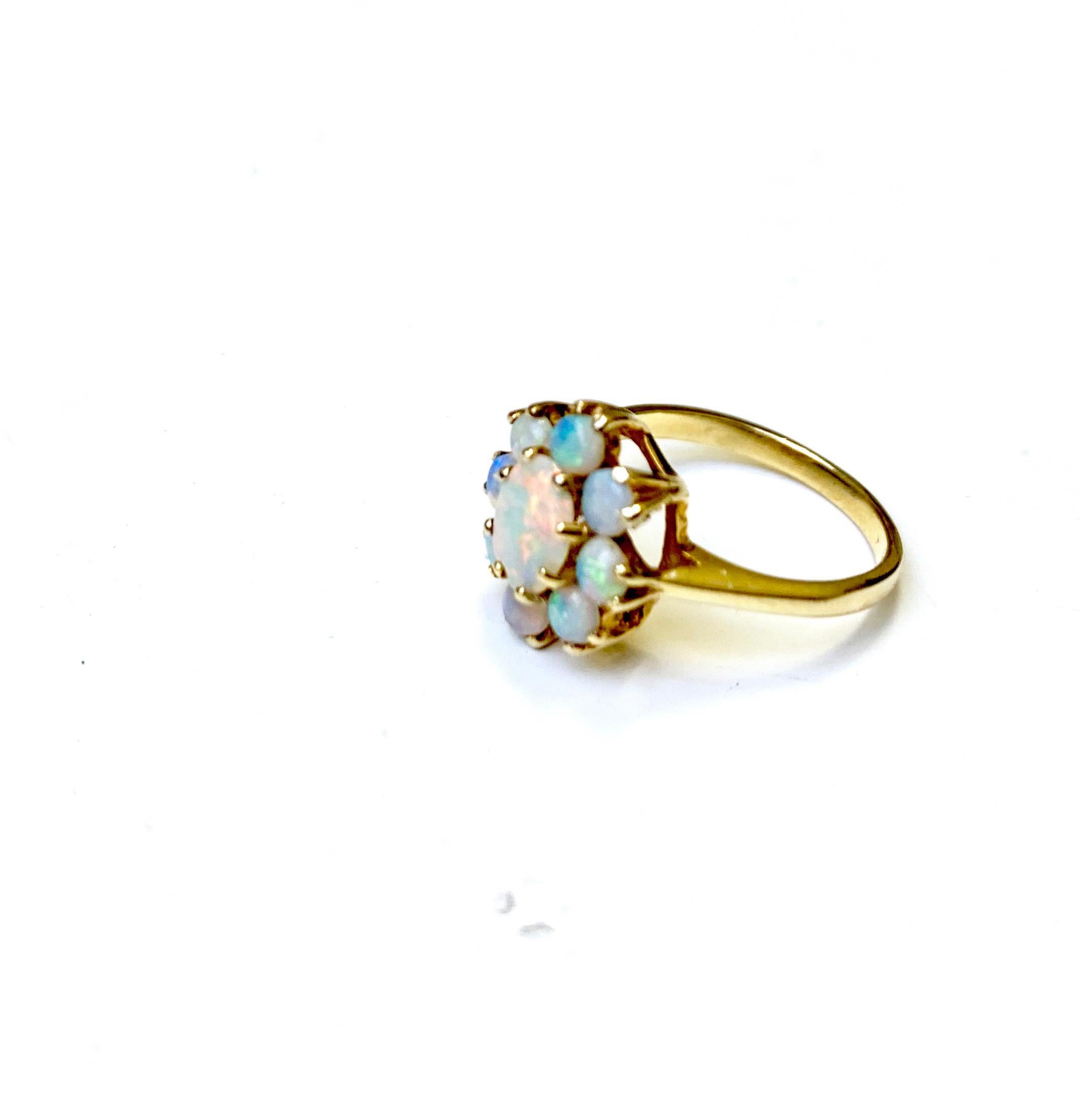 2ctw. opal ring has nine stones total.  The center stone is 6x4mm and 3mm opal cabochons set in 14k yellow gold.  The ring is cast from 14k yellow gold and sized currently to a 5 but can be sized once purchased.  The ring is dated to the Victorian