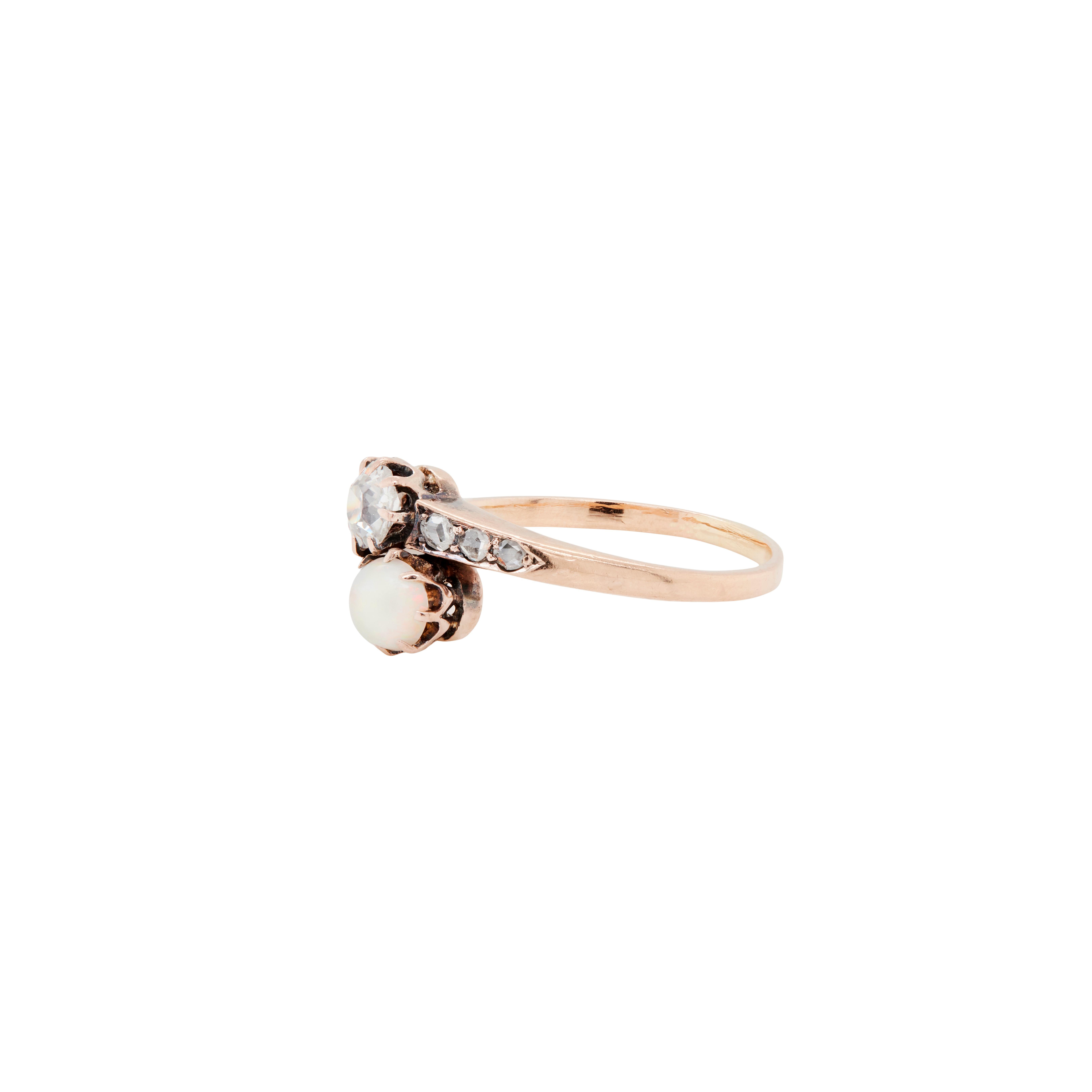 Préparez-vous à tomber amoureux de la beauté envoûtante de cette authentique bague de fiançailles édouardienne Toi et Moi, datant des années 1900 - un design romantique qui symbolise l'union de deux âmes.

Au centre, une opale lumineuse d'environ