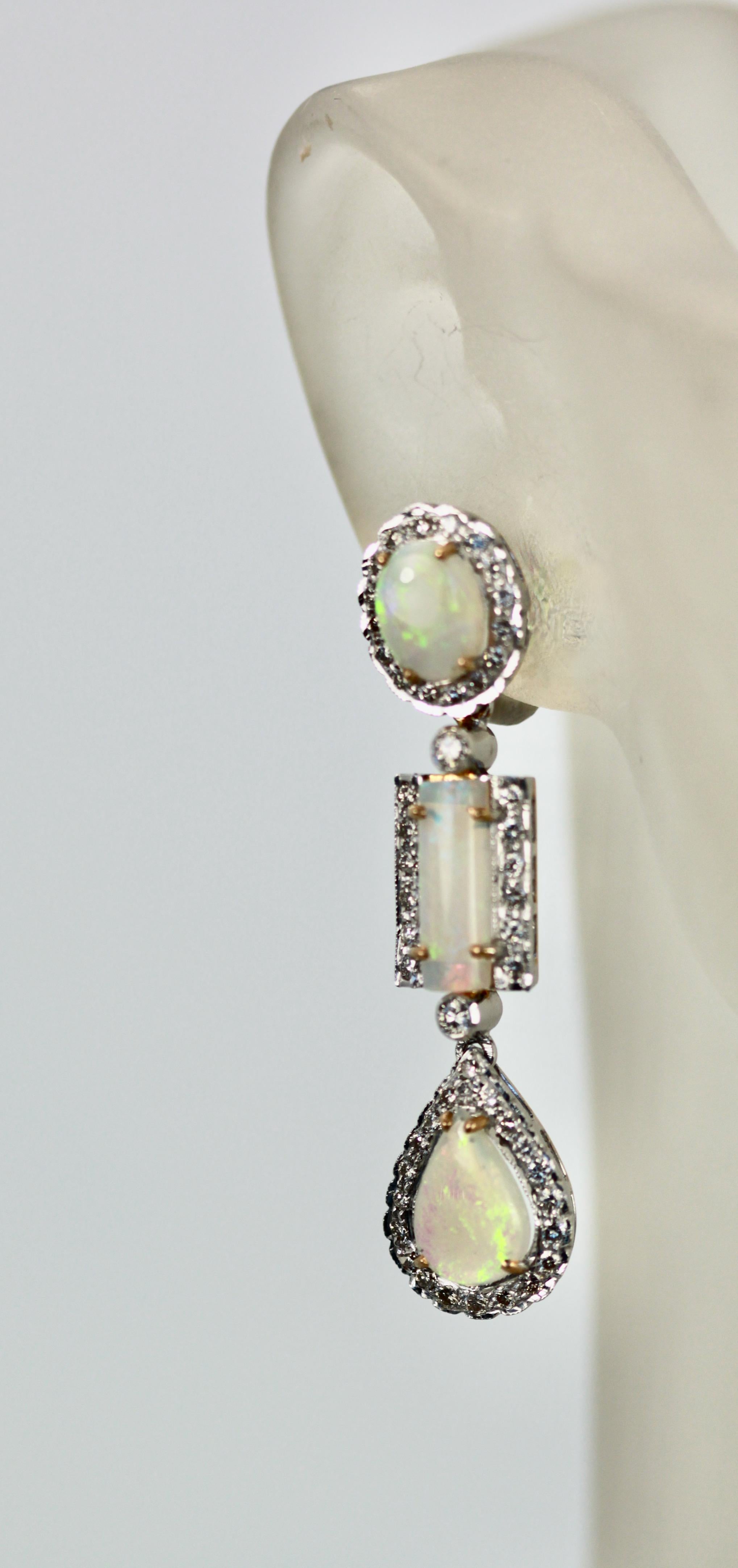 These beautiful Opal Diamond drop earrings are made in 18K Yellow Gold.  There are 3 Opals per earring each Opal with a Diamond surround.  One oval Opal of 1 carat, one rectangle Opal .75 carats, One teardrop Opal at 1.50 carats, to total 3.15