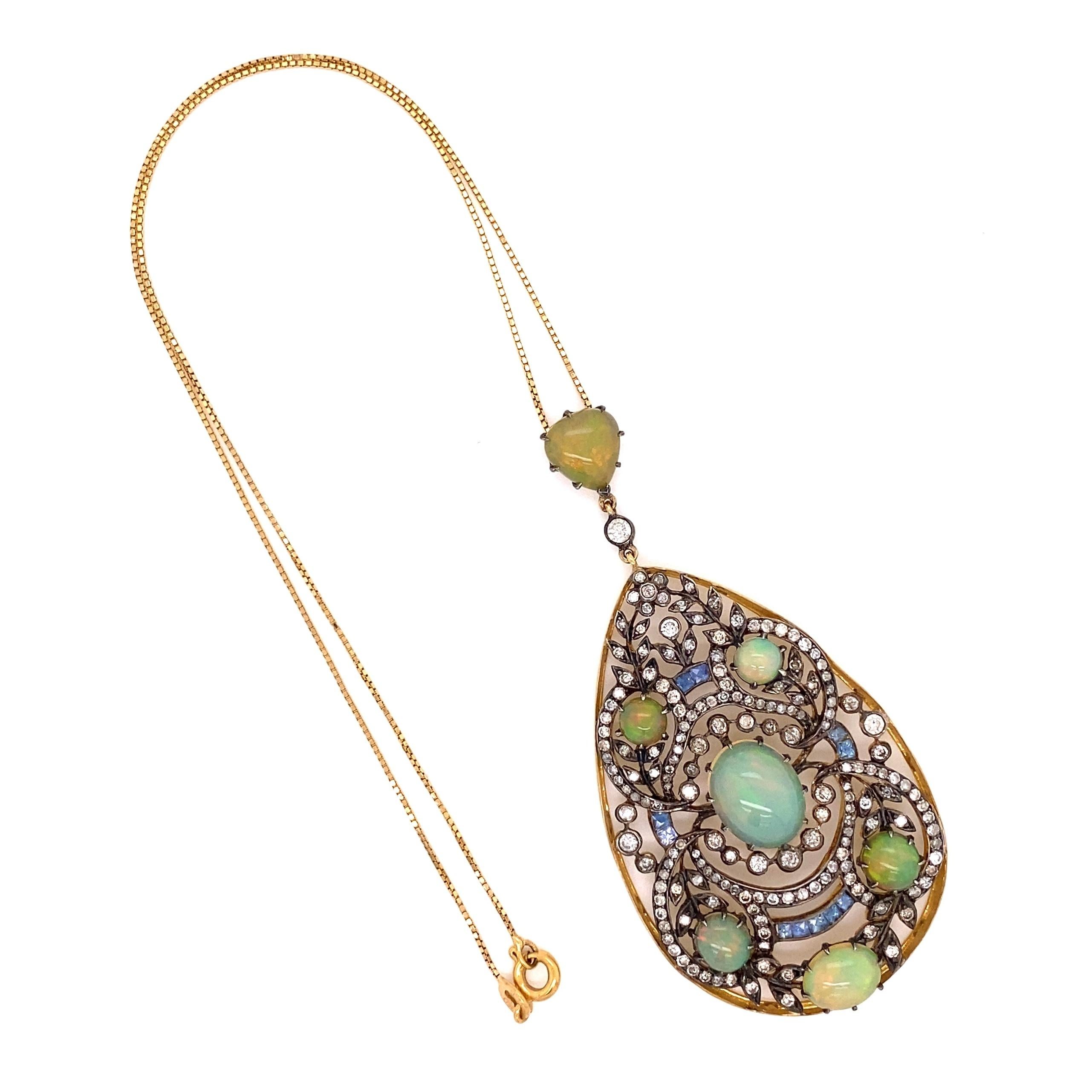 Simply Beautiful! Elegant and finely detailed Opal, Diamond and Sapphire Pendant Necklace suspended from a 15” long 18K Yellow Gold Chain. Securely Hand set with Opals, weighing approx. 8.53tcw, Diamonds, approx. 2.55tcw and Sapphires, approx.