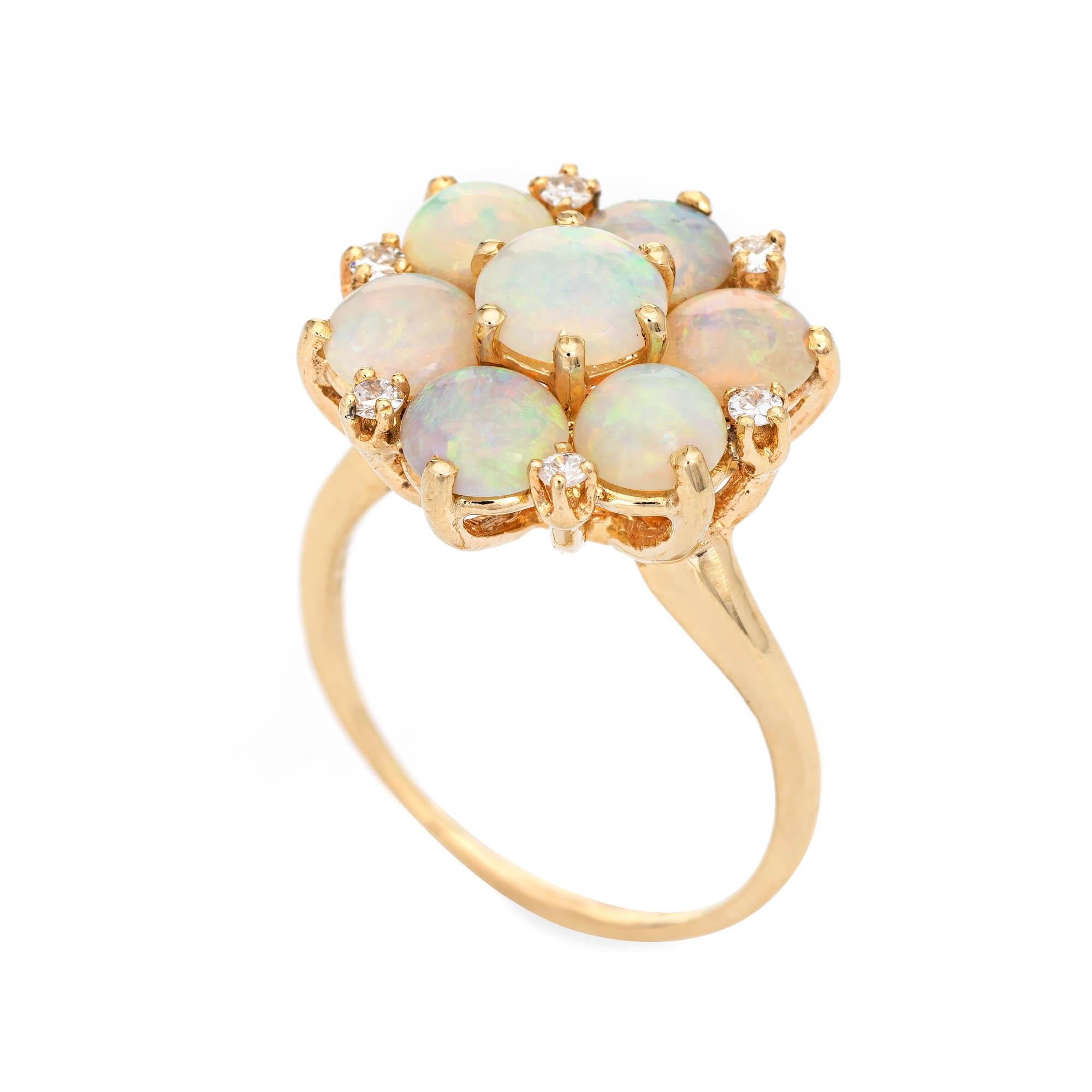 Stylish vintage opal & diamond cluster cocktail ring crafted in 14 karat yellow gold. 

The center opal measures 6mm and is estimated at 0.60 carats, accented with six opals estimated at .50 carats each. the total opal weight is estimated at 3.60