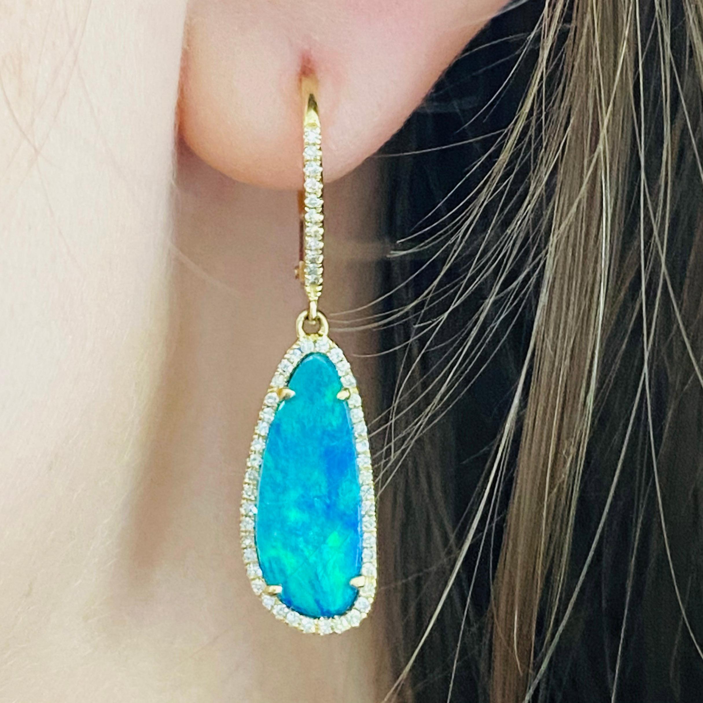 How stunning are these diamond and opal earring dangles? The genuine, natural opal and diamonds are set in a 14k yellow gold earring setting. The yellow gold compliments the natural blue and green flashes in the genuine opal gemstones. Opal is the