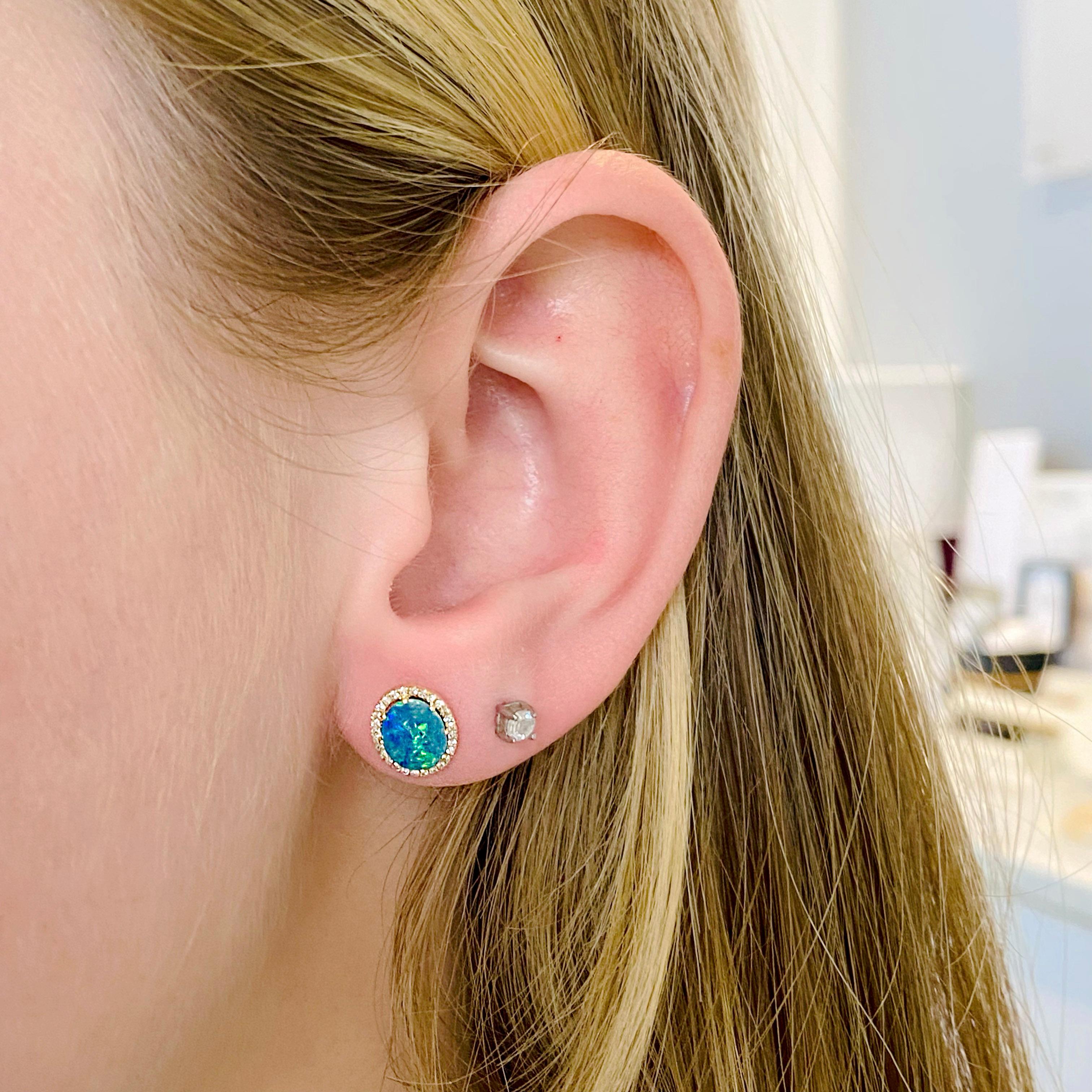 Ces boucles d'oreilles en opale noire avec des diamants en halo sont de magnifiques clous d'oreilles. Elles sont serties en or jaune 14 carats et constituent une belle déclaration. Le poids total des opales et des diamants est de 0,94 carats. Ils
